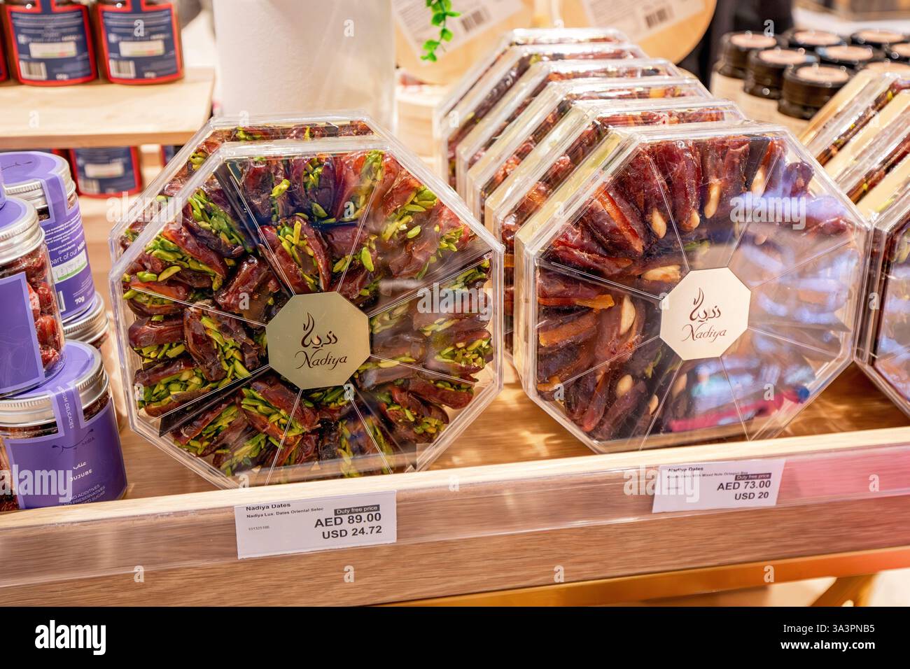 23. Januar 2025, Abu Dhabi, VAE: Köstliche Datteln und Pistazien in einer achteckigen, transparenten Kunststoffbox, die in einem Ladenregal zum Kauf bereit ist Stockfoto