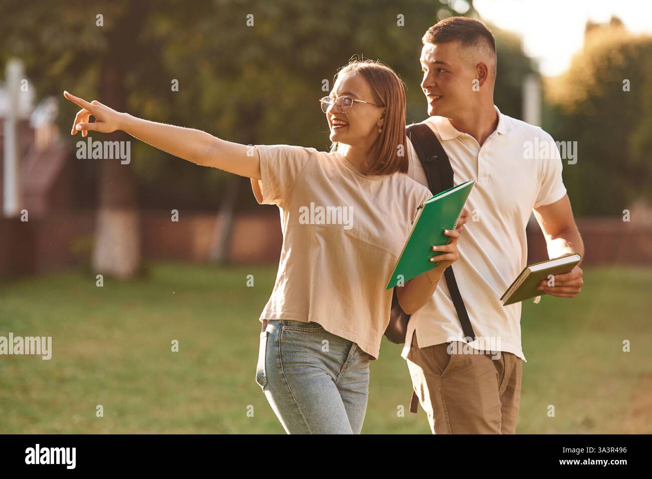 Etwas mit dem Finger zeigen. Zwei Studenten sind draußen. Stockfoto
