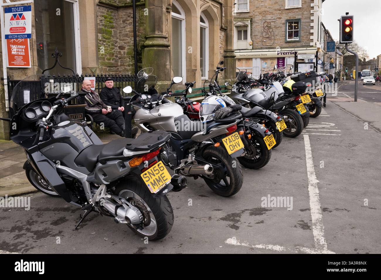 Tourenmotorräder parken auf dem Hauptplatz der Yorkshire Dales Stadt Settle (ein beliebter Zwischenstopp für Motorräder), North Yorkshire, Großbritannien. Stockfoto