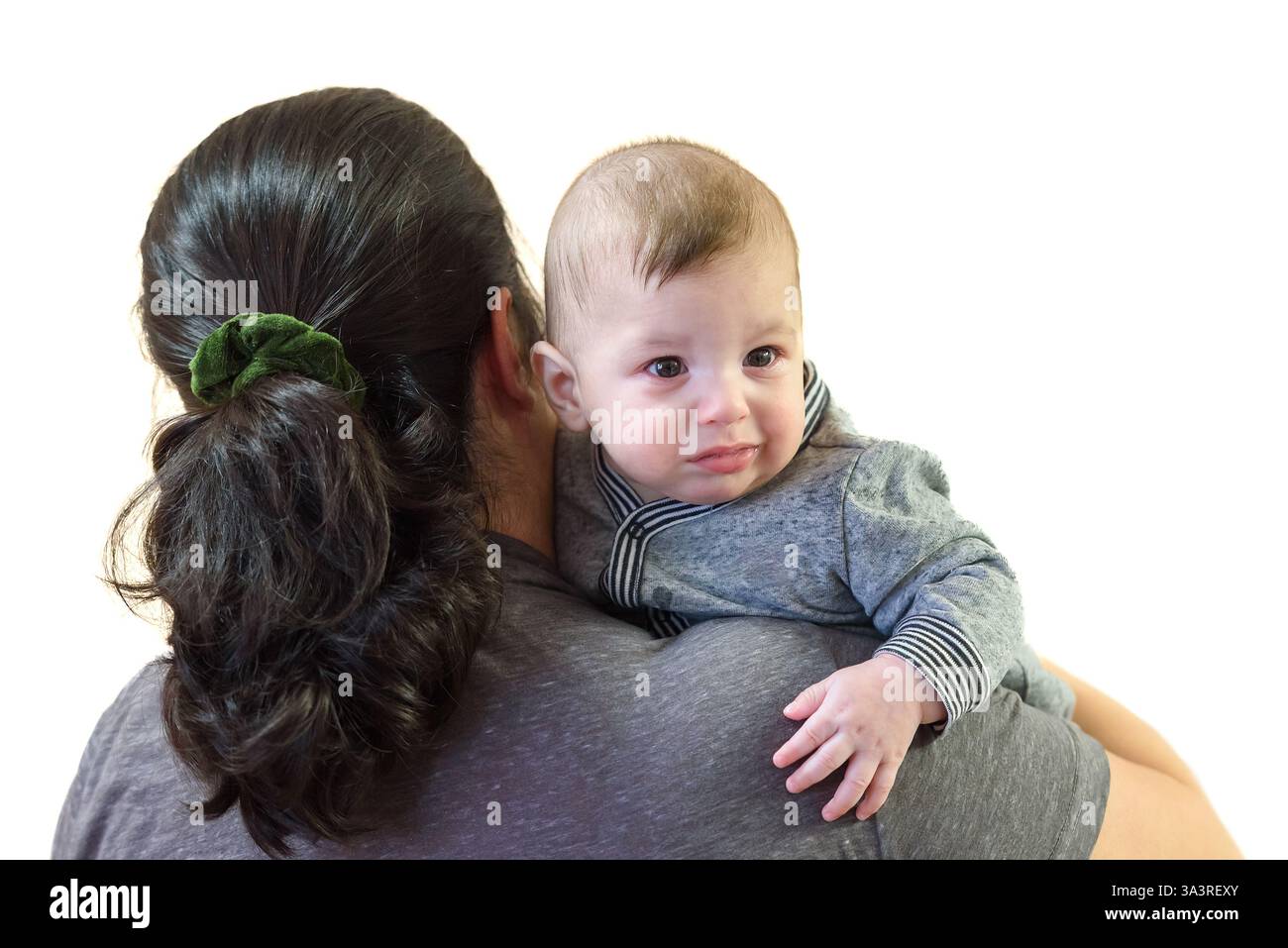 Frau, die ihren Jungen vor weißem Hintergrund hält Stockfoto
