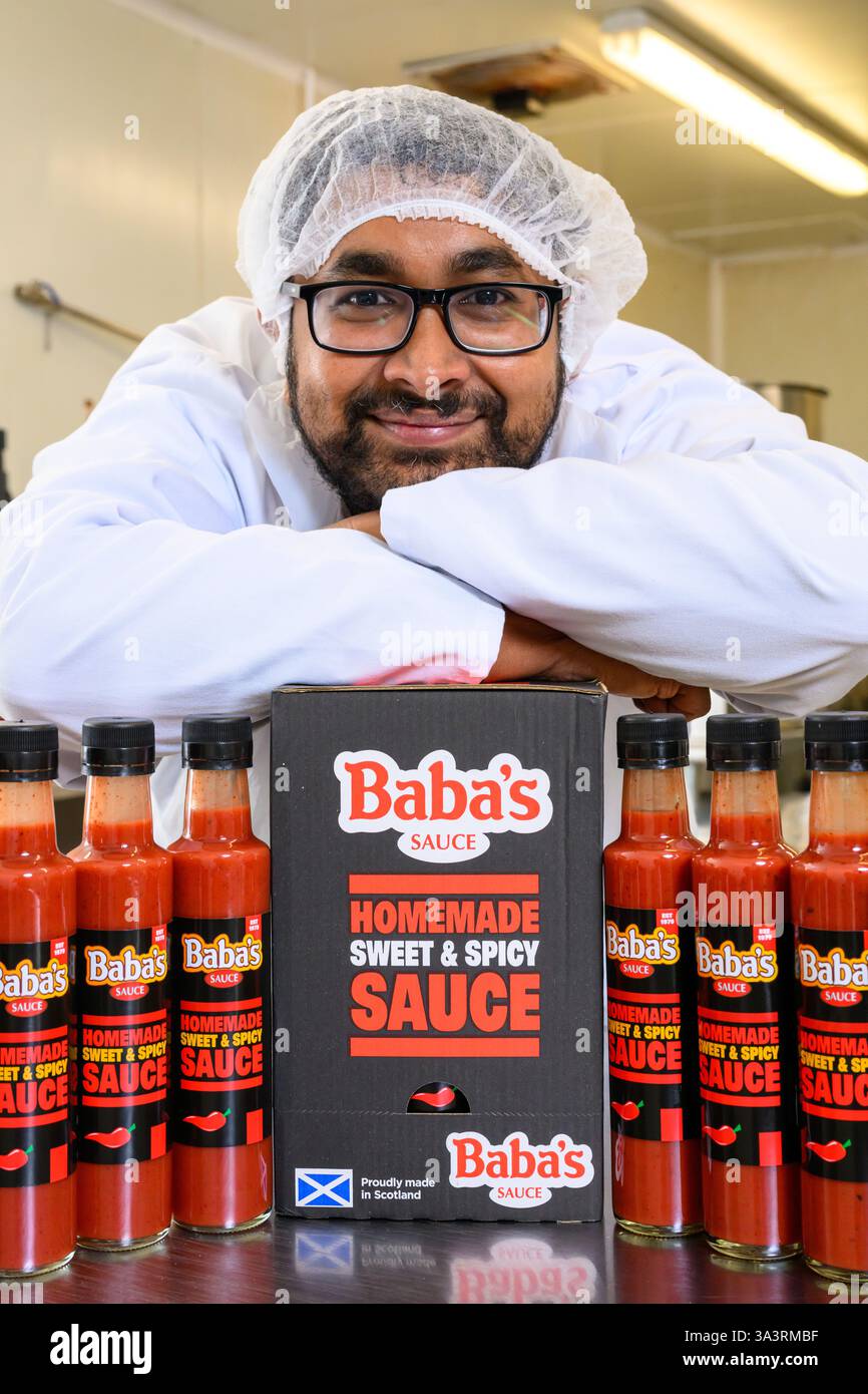 Sunny Mollah, Gründer von Baba's Sauce, mit Flaschen seiner scharfen Soße, Schottland, UK Stockfoto