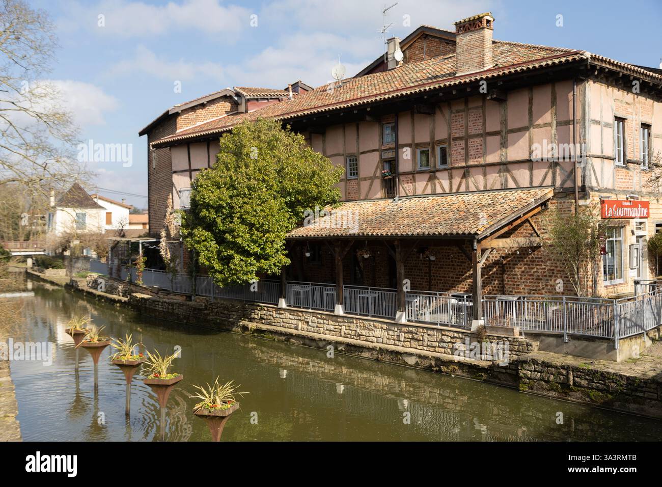 Ein Restaurant am Fluss in einem mittelalterlichen Fachwerkgebäude an der Chalaronne in Châtillon-sur-Chalaronne, Ain, Frankreich. Stockfoto