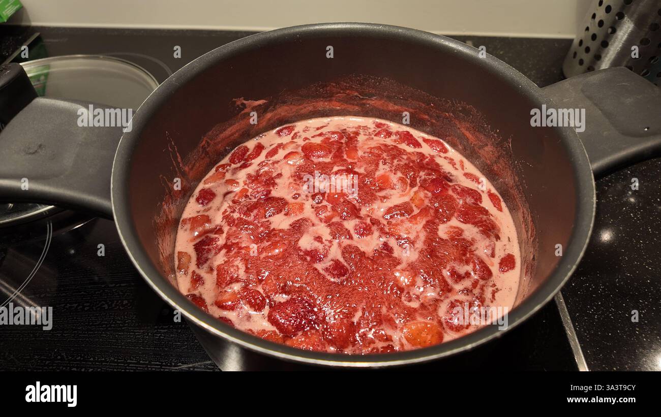 Topf mit kochenden Erdbeeren, um hausgemachte Marmelade zu machen Stockfoto