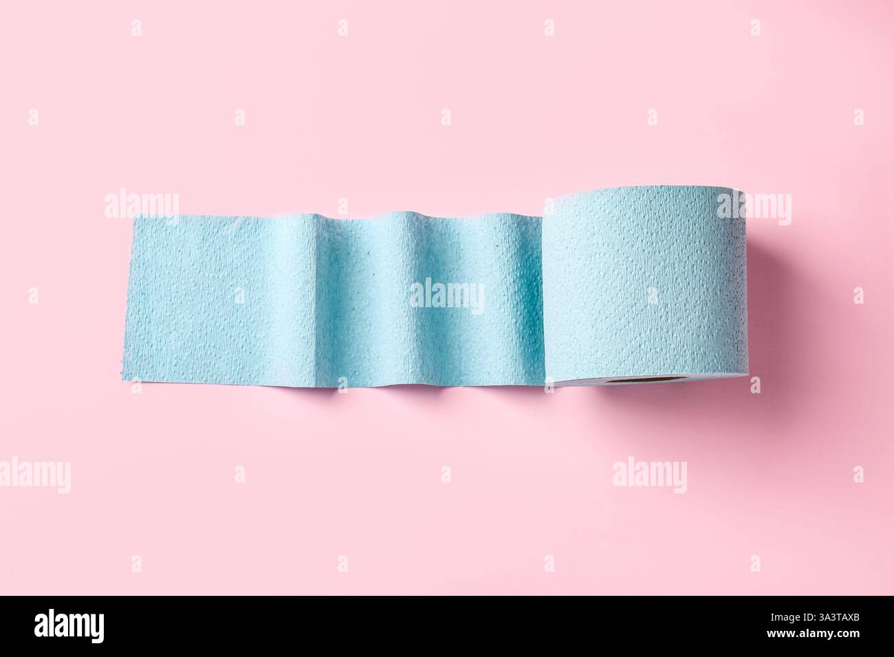 Blaue Toilettenpapierrolle auf hellrosa Hintergrund, Draufsicht Stockfoto