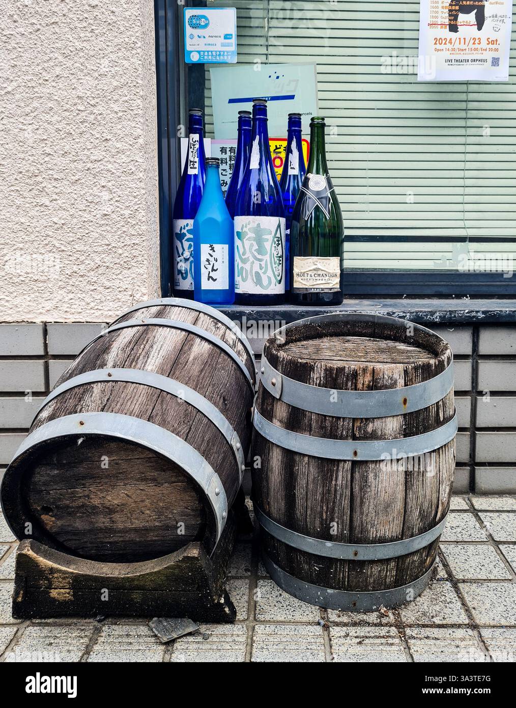 Leere Bierfässer und Alkoholflaschen am frühen Morgen vor einer Bar in Tokio. Stockfoto