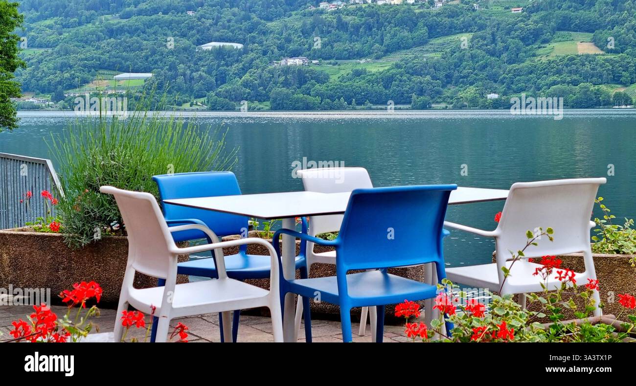 Gemütliche Ecke eines offenen Veranda-Restaurants am Ufer des Lago di Caldonazzo, Trentino, Italien Stockfoto