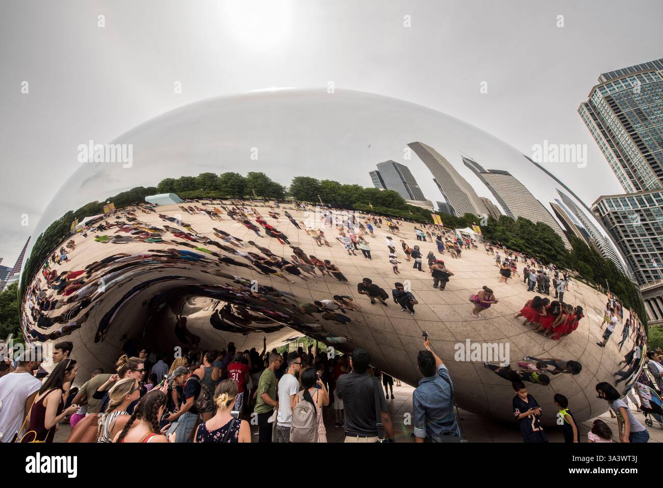 Die Menge versammelte sich um Reflective Public Art im Urban Park Stockfoto