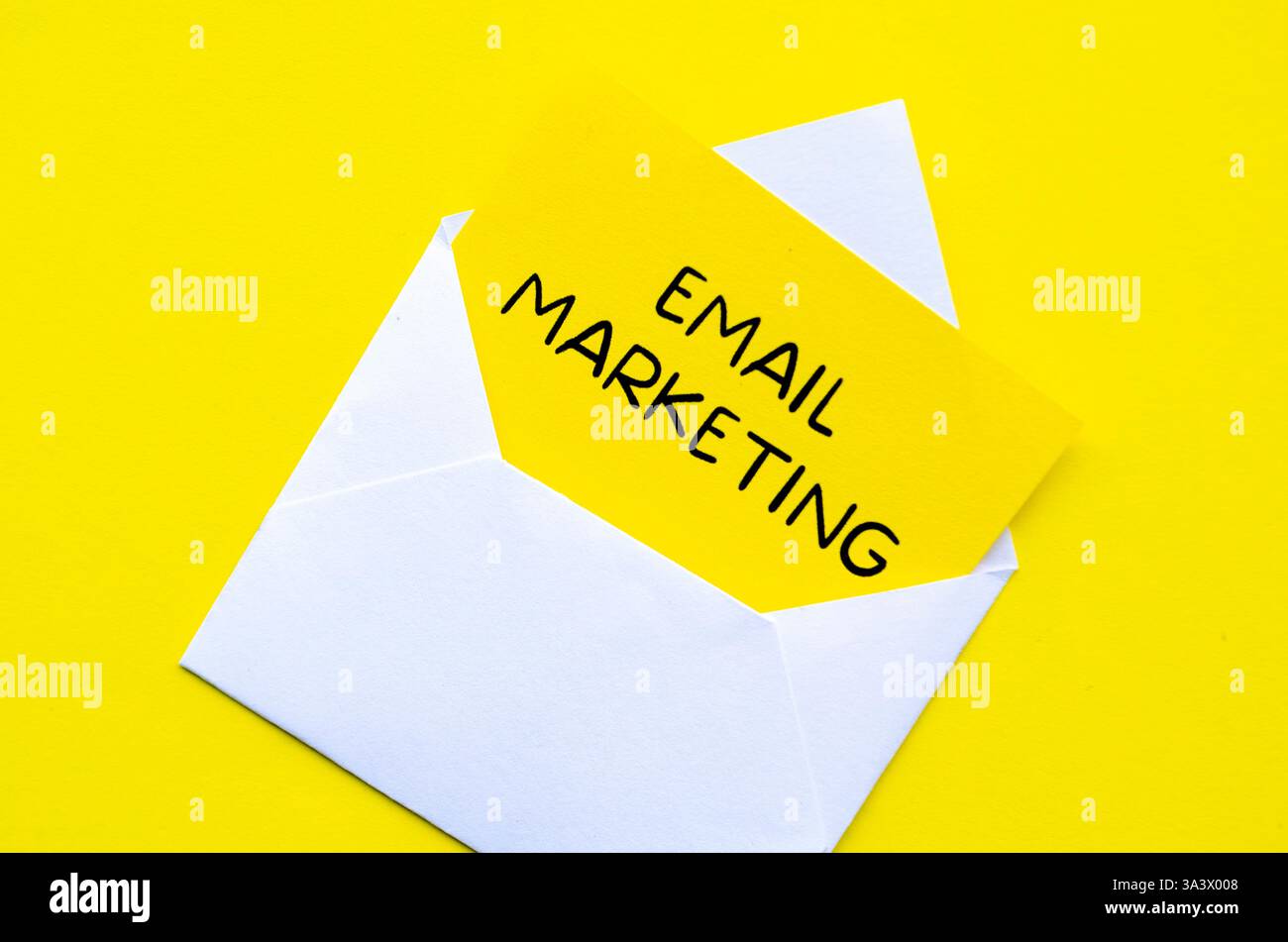 E-Mail-Marketingtext auf gelbem Notizblock in einem weißen Umschlag. Online-Konzept „Geld verdienen“. Stockfoto