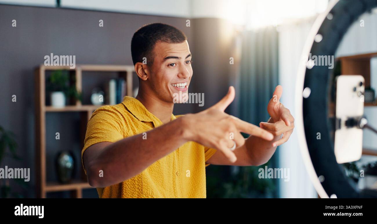 Mann, Influencer und soziales Netzwerk mit Ringlicht zu Hause für Livestream, Video oder Post mit Emoji. Person, Selfie und glücklich mit Symbol für Chat Stockfoto