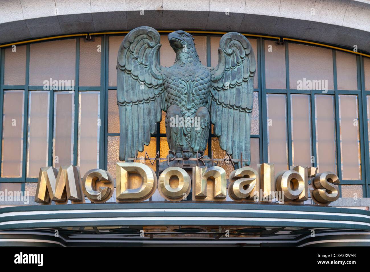 Goldenes, bronzenes McDonald's Imperial Restaurant-Logo mit bronzenem Adler in Porto Portugal. Das Gebäude ist im Art déco-Stil Stockfoto
