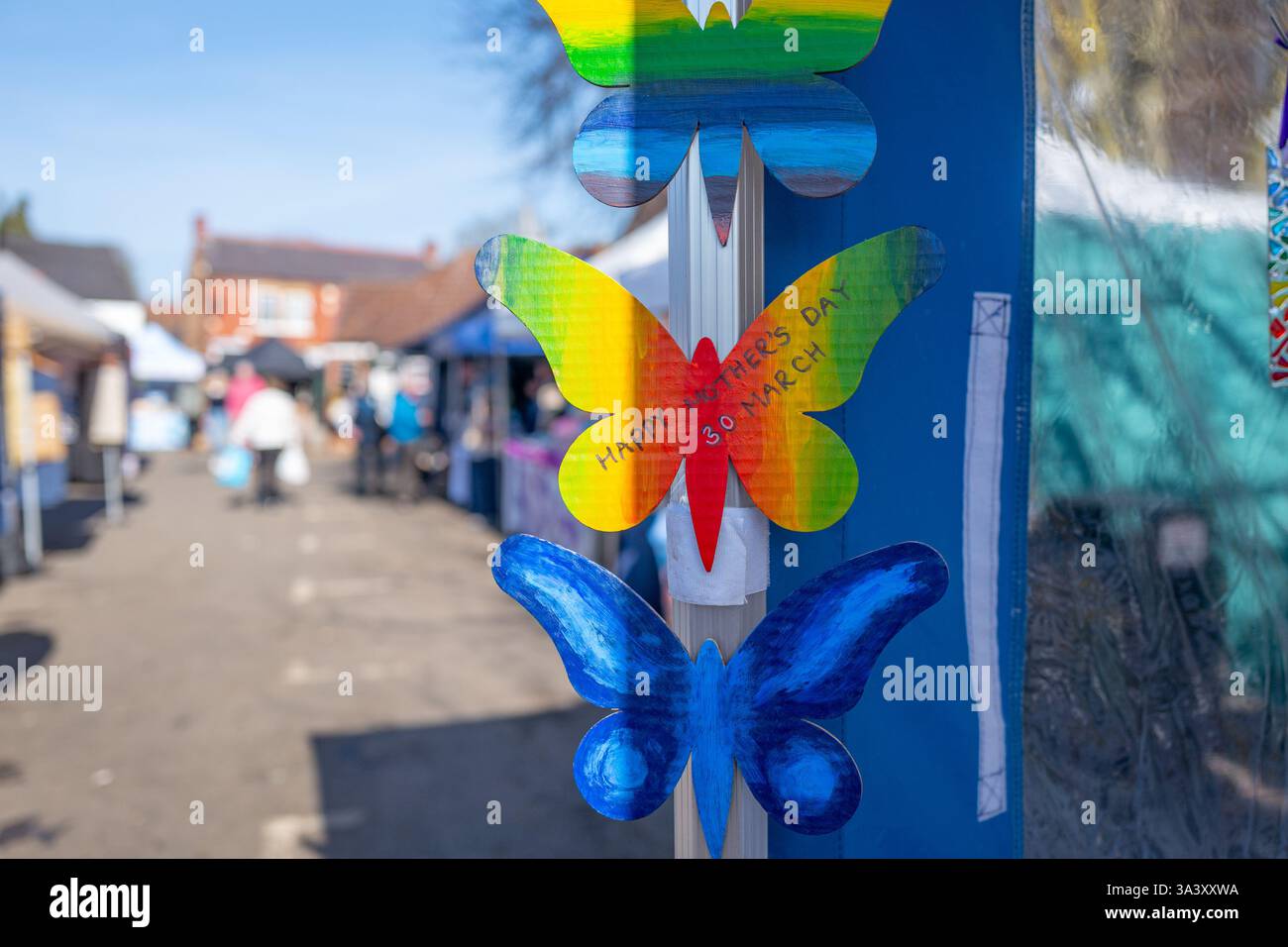 Happy Mothers Day, geschrieben auf einem bunten Ausschnitt eines Schmetterlings an einem Marktstand am Markttag in Easingwold, North Yorkshire. Stockfoto