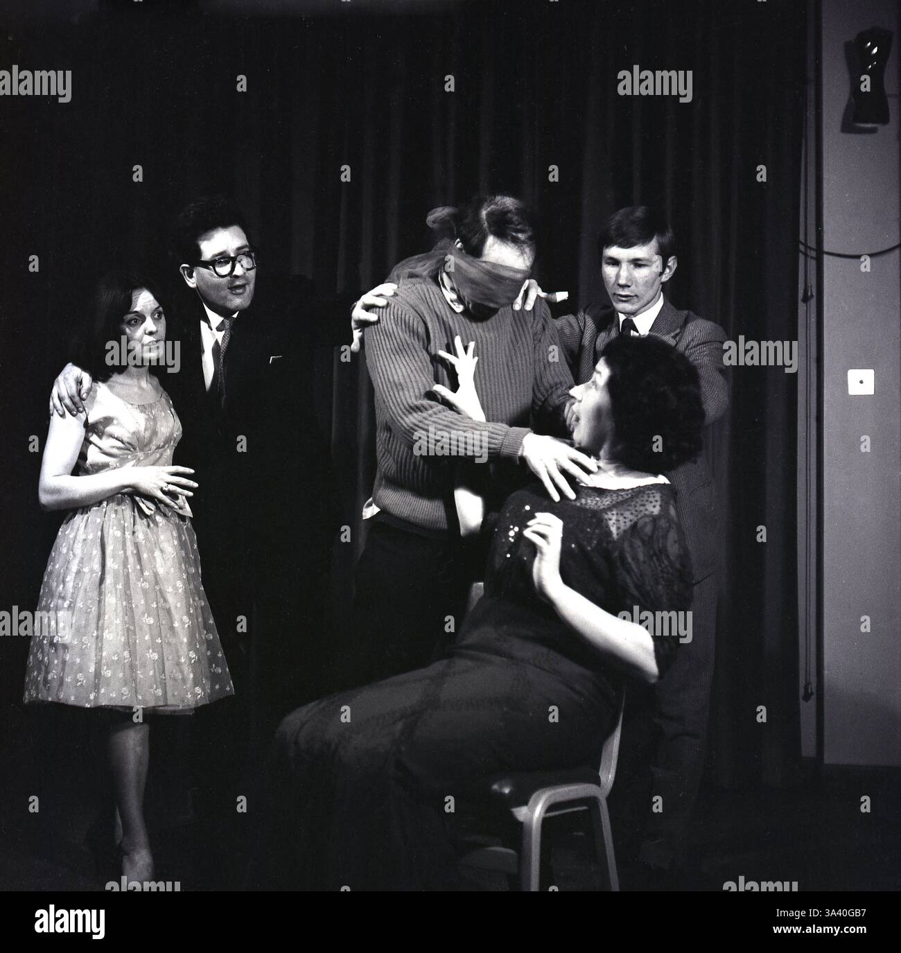 1965, historische Schauspieler auf der Bühne in The Birthday Party von Harold Pinter, seinem ersten abendfüllenden Stück und einem seiner bekanntesten und am häufigsten gespielten Stücke. Im Mittelpunkt der Handlung steht eine kleine Geburtstagsfeier für Stanley Webber, einen einstigen Klavierspieler im Alter von 30 Jahren, der in einer heruntergekommenen Pension am Meer lebt. Die Pension wird von Meg und Petey Boles geleitet, die die Party für ihn abhalten. Zwei unheimliche Fremde, Goldberg und McCann, kommen und scheinen nach ihm zu suchen. Unter ihnen verwandeln sie Stanleys scheinbar harmlose Geburtstagsparty in einen Albtraum. Stockfoto