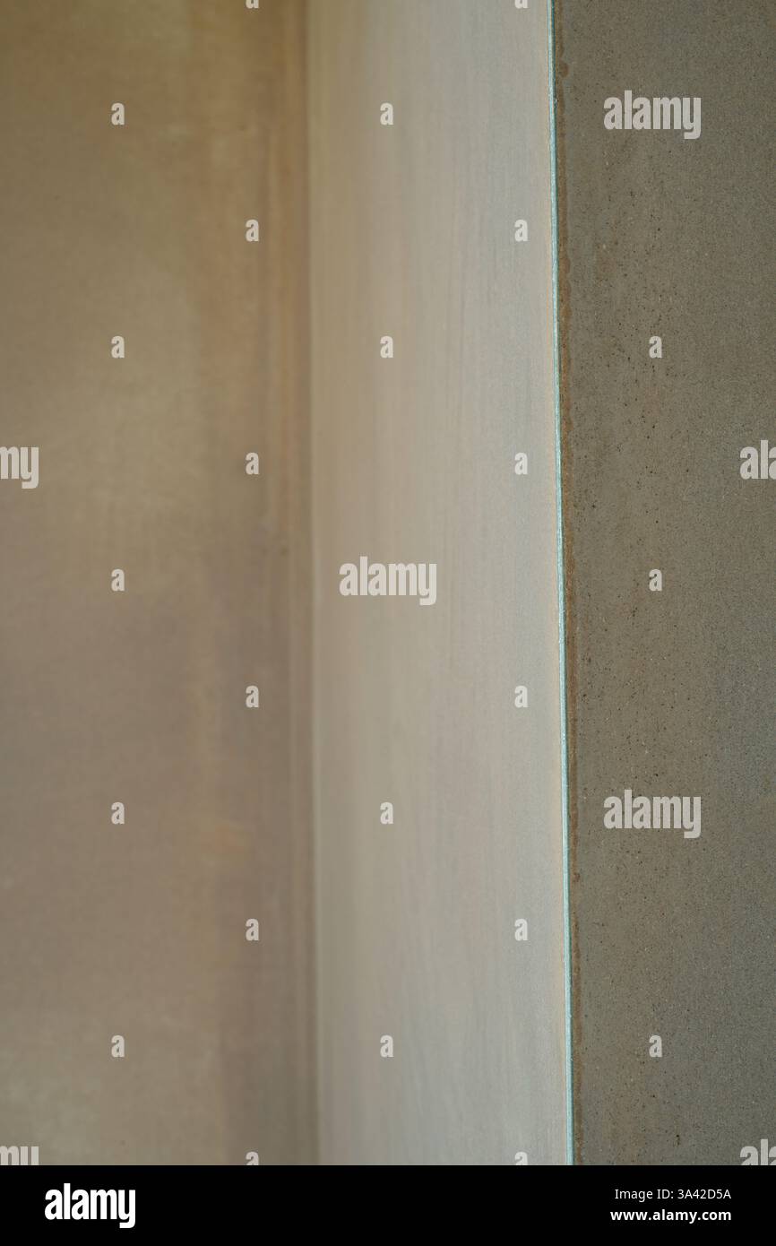 Ein neu verputzter Raum mit scharfen Kanten und einer sehr glatten Oberfläche. Die Bauarbeiten wurden mit einer glatten, flachen Oberfläche aus dünnem Putz abgeschlossen. Ein großartiges Können. Stockfoto