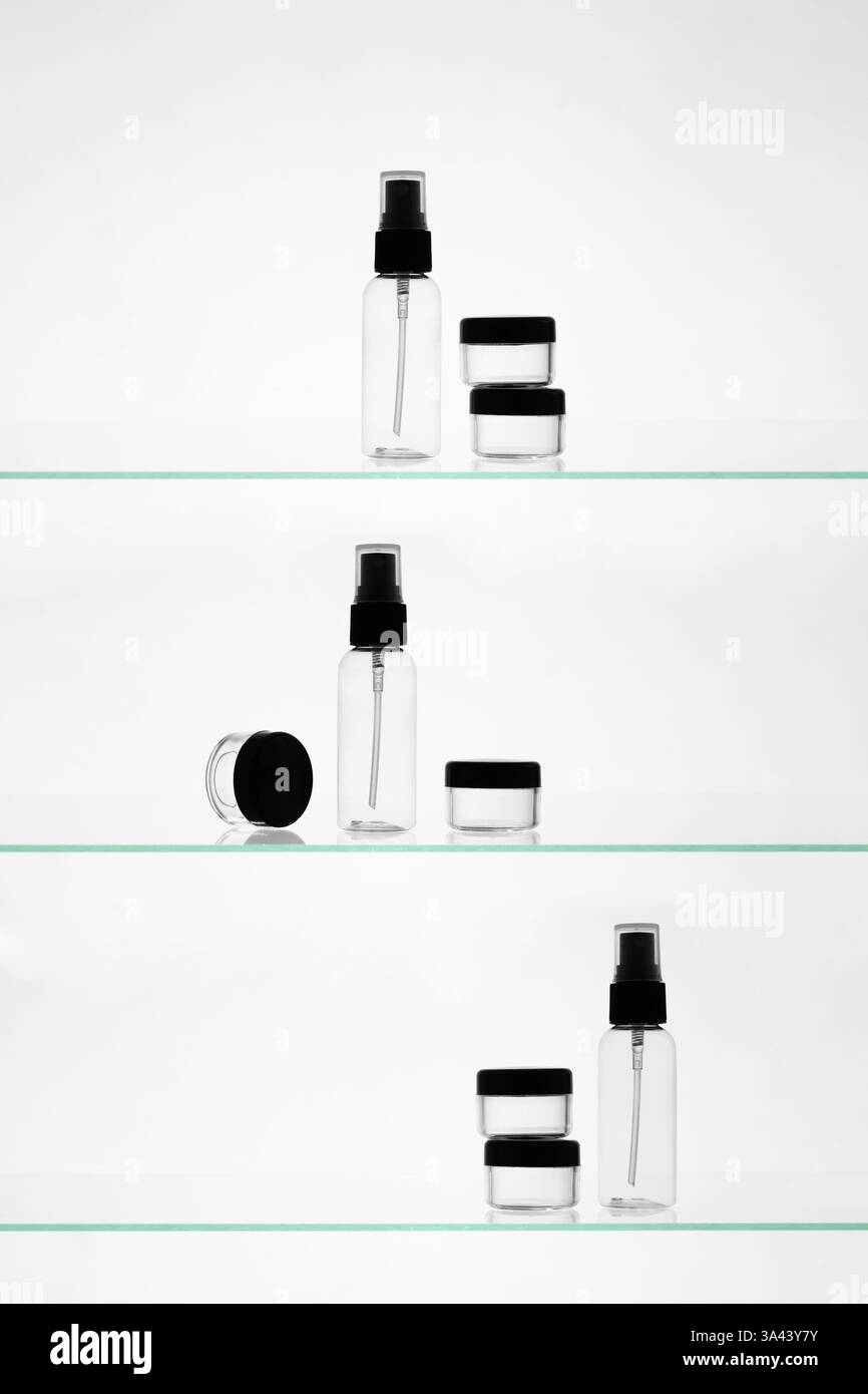 Leere Kosmetikprodukte auf einem Glasregal. Transparente Mockup-Flaschen in verschiedenen Größen für Werbung auf weißem Hintergrund Stockfoto