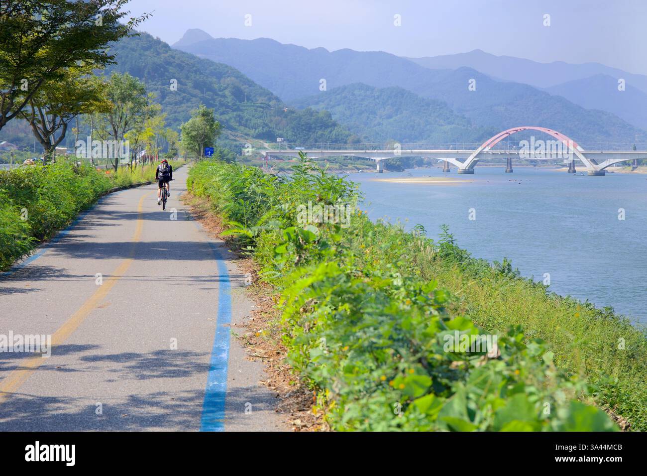 Gwangyang, Südkorea - 3. Oktober 2021: Ein Radfahrer fährt entlang des Seomjingang Bike Path, der parallel zum Seomjin verläuft. Im Hinterland Stockfoto