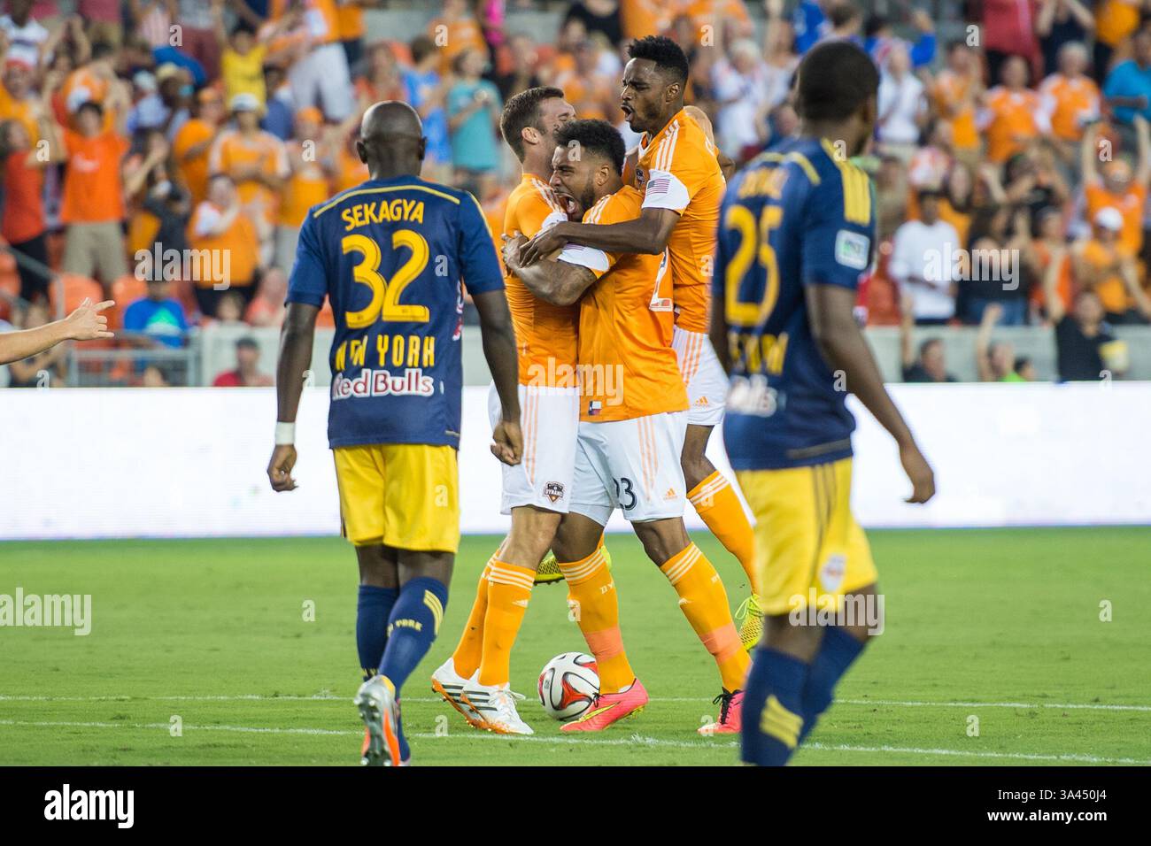 Juli 2014: Houston, Texas, USA S - Houston Dynamo Stürmer Giles Barnes (23) feiert sein Tor, das in der 39. Sekunde des Spiels mit Houston Dynamo Stürmer will Bruin (12) und Houston Dynamo Verteidiger Warren Creavalle (5) bei einem MLS-Spiel zwischen den Houston Dynamo und den New York Red Bulls am 4. Juli 2014 im BBVA Compass Stadium in Houston, Texas, Texas, erzielt wurde. Das Spiel endete mit einem Unentschieden von 2-2. (Bild: © Trask Smith/ZUMA Wire) Stockfoto
