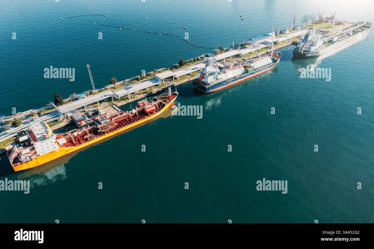 Luftaufnahme mehrerer Tankschiffe, die am Tankterminal im Küstenhafen angedockt sind. Industrieschiffe zum Be- und Entladen von Rohöl, Gas und Petrochemikalien für den weltweiten Transport. Stockfoto