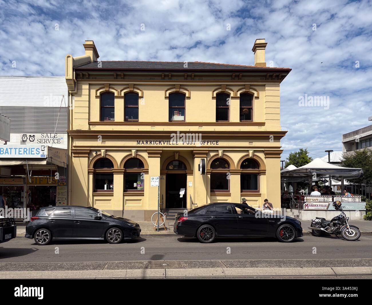 Das Marrickville Post Office ist ein historisches Sandsteingebäude mit geparkten Autos davor. Stockfoto