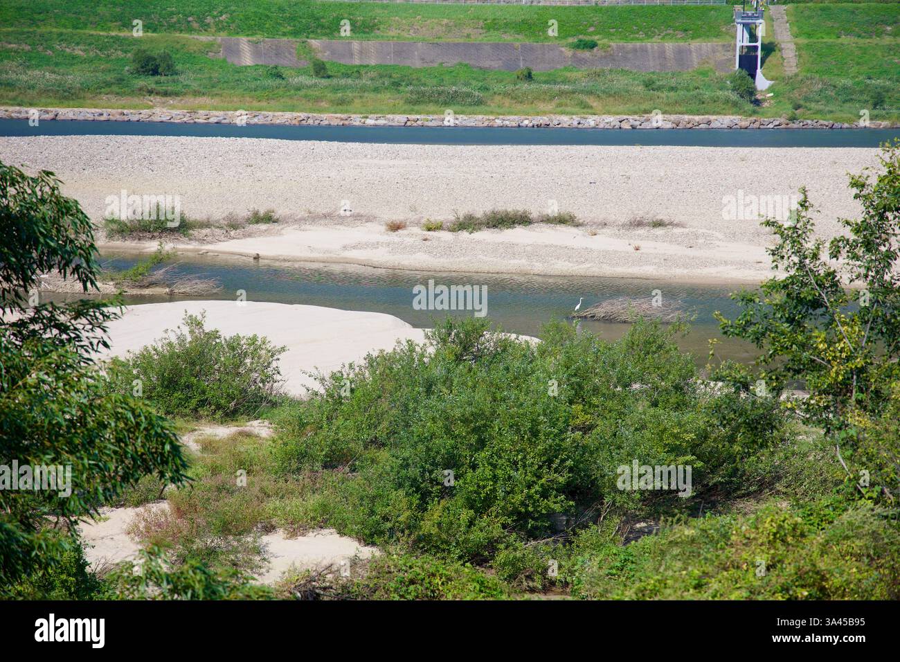Gwangyang City, Südkorea - 3. Oktober 2021: Ein ruhiger Blick auf den Seomjingang River mit Sandbank, grüner Vegetation und einsamem Reiher Stockfoto
