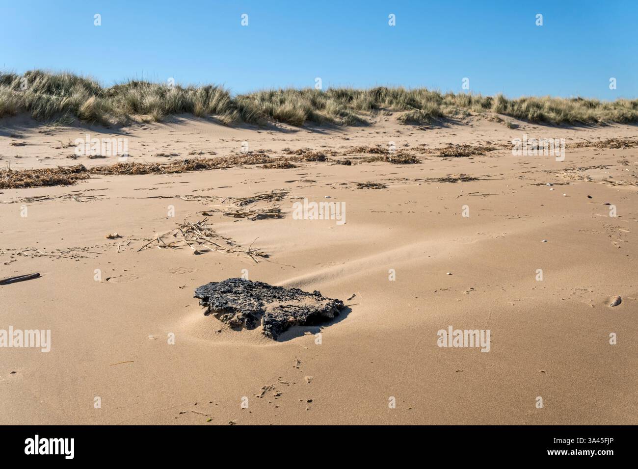 18. März 2025. Kunststoffverschmutzung in Form verbrannter und geschmolzener Nurdles (Pellets aus Kunststoffharz), die an einem Strand von North Norfolk nach der Kollision des Containerschiffs Solong und der Stena Immaculate vor der Mündung von Humber am 10. März 2025 angespült wurden. Stockfoto