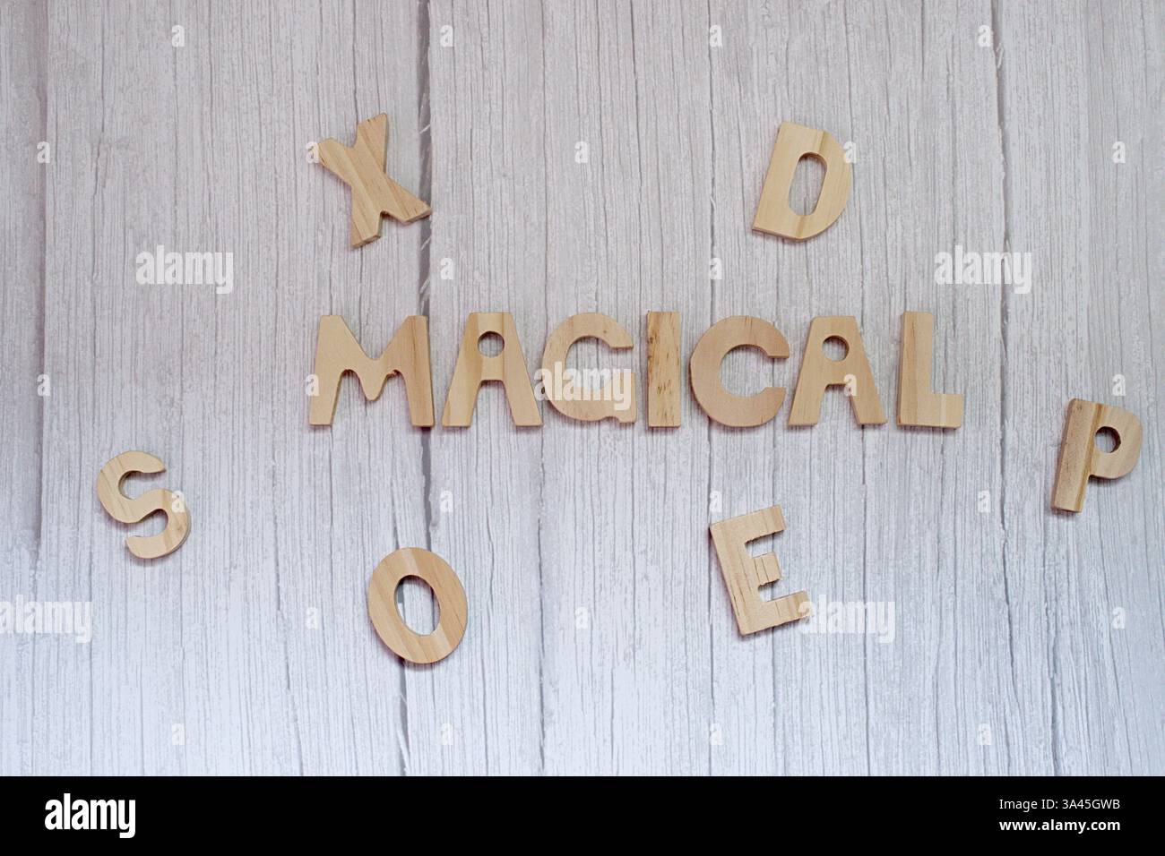 Blick von oben auf das Wort magische aus Holzbuchstaben auf einem Holztisch Stockfoto
