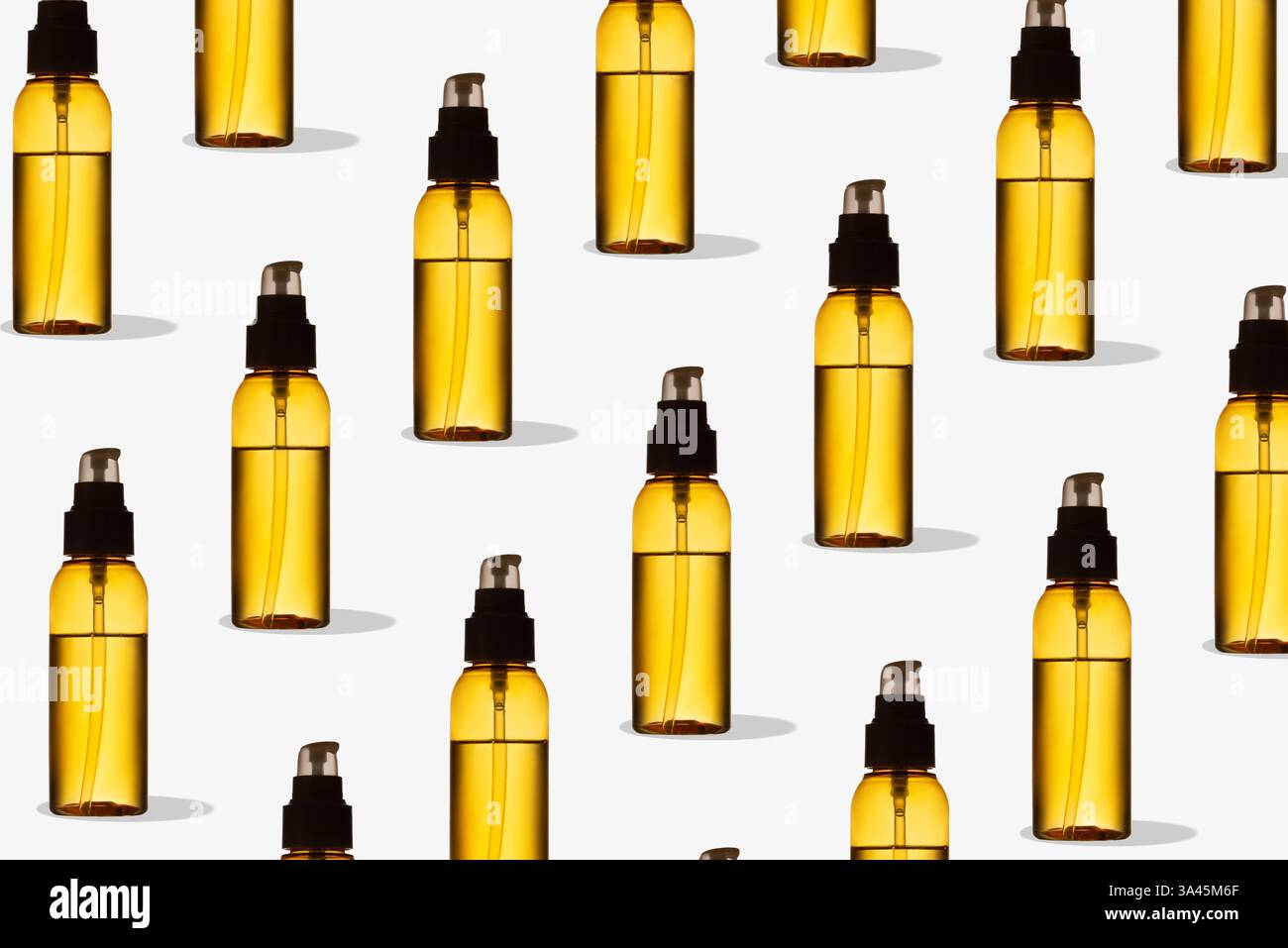 Muster der gelben transparenten Ölflasche auf weißem Hintergrund. Mockup von Hautpflegeprodukten. Kreative Fotografie für Schönheitsprodukte Stockfoto