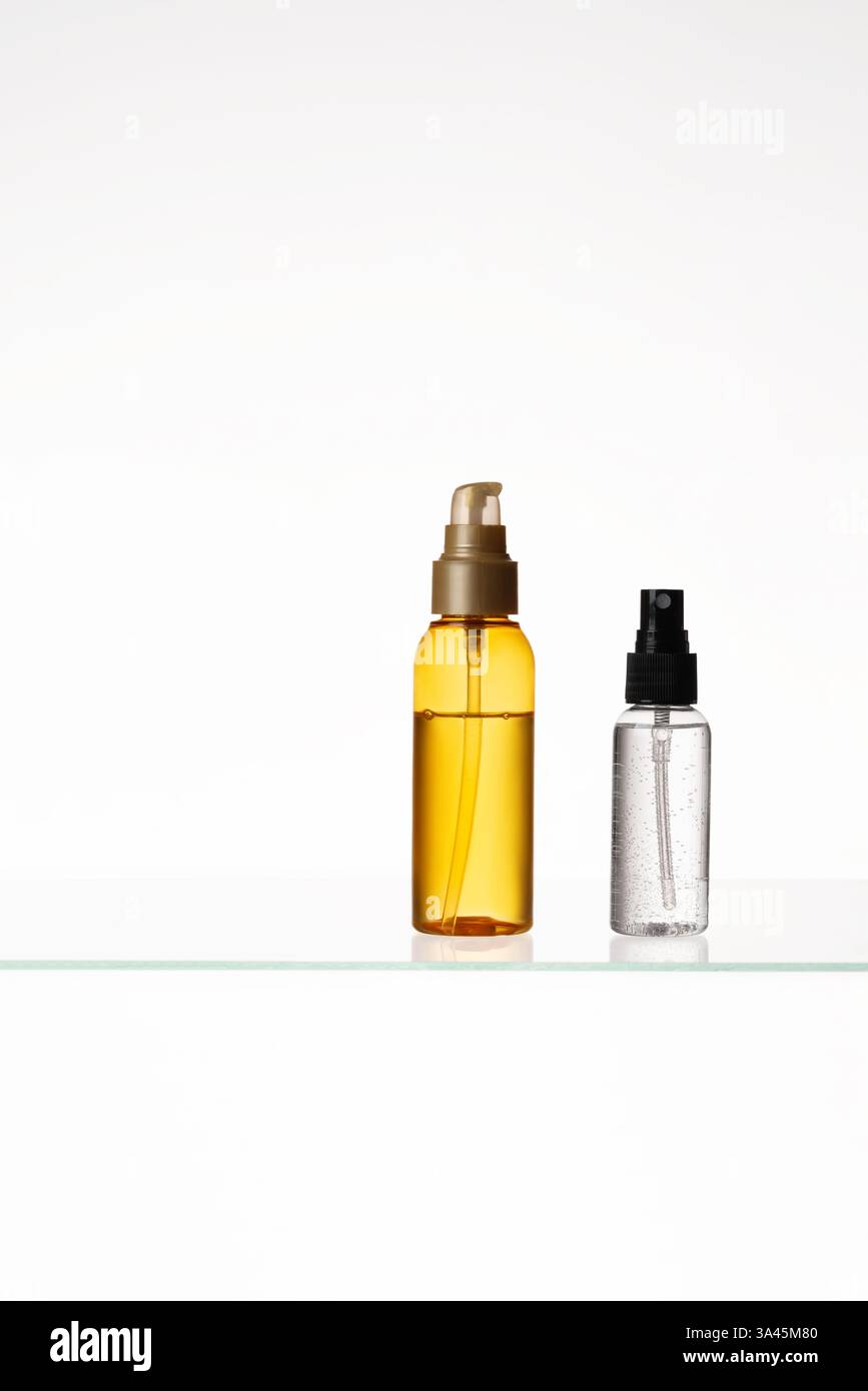 Kosmetische Produkte auf einem Glasregal auf weißem Hintergrund. Mockup von Hautpflege- und Badeprodukten auf einem Glasregal. Spender und Röhrchen Stockfoto
