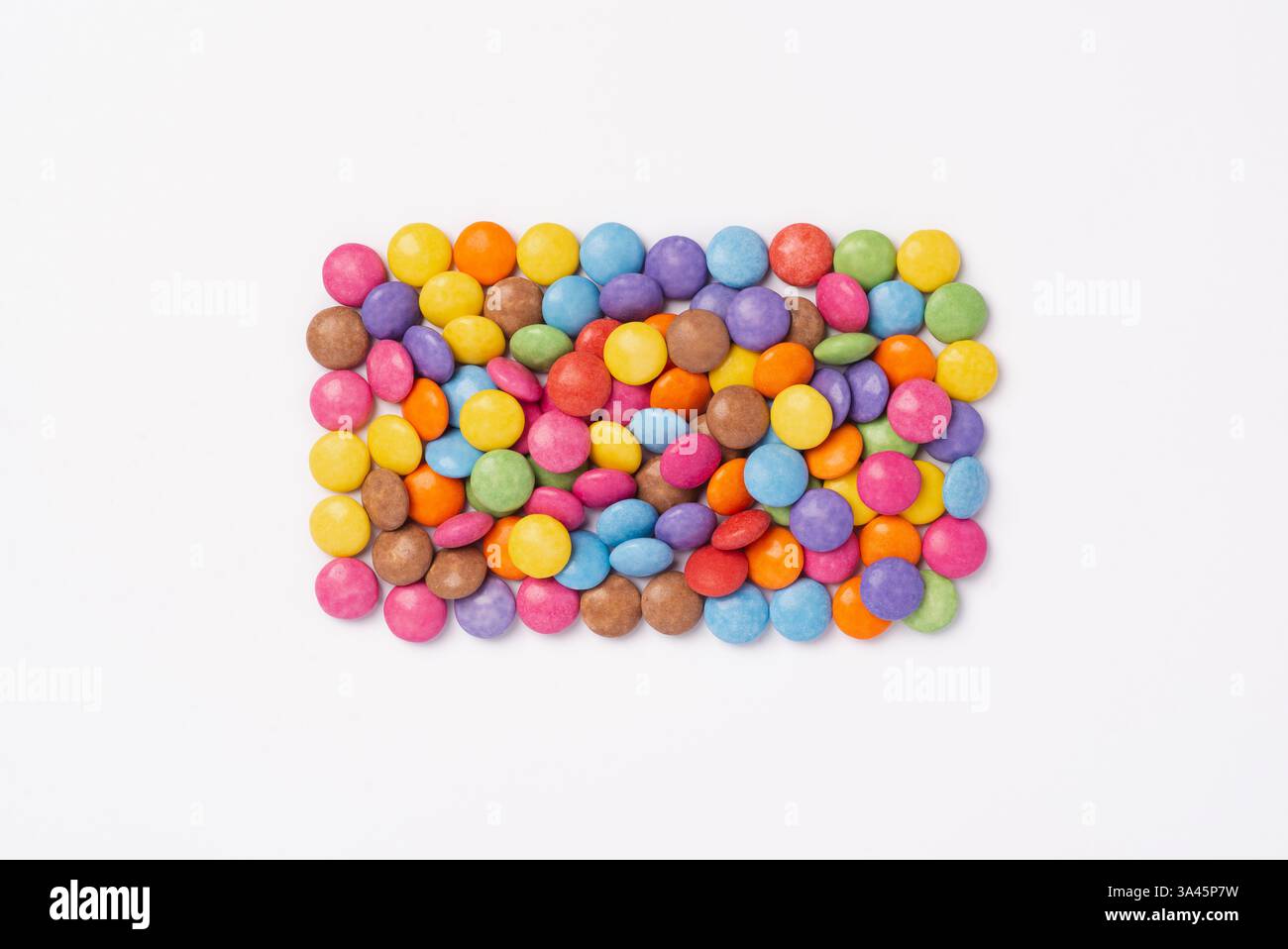 Bunte Süßigkeiten auf weißem Hintergrund. Regenbogenfarbene Süßigkeiten. Glücklichkeits- und Fröhlichkeits-Konzept, Draufsicht, Kopierraum Stockfoto