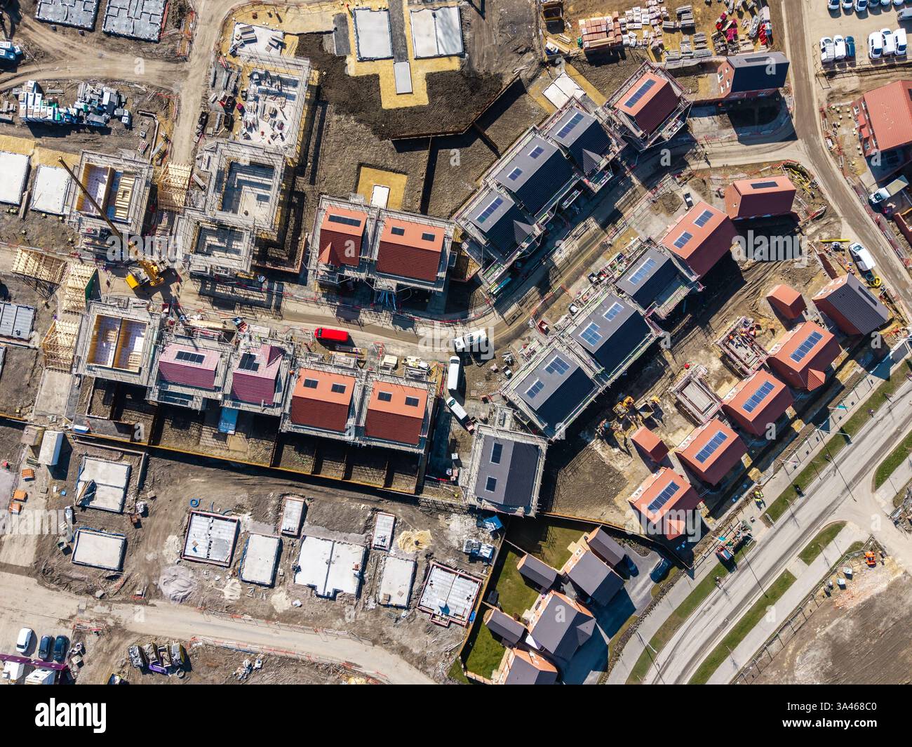 Blick von oben nach unten über einer Baustelle, die neue und erschwingliche umweltfreundliche Häuser mit Solarpaneelen in Großbritannien auf Grüngürtel baut Stockfoto