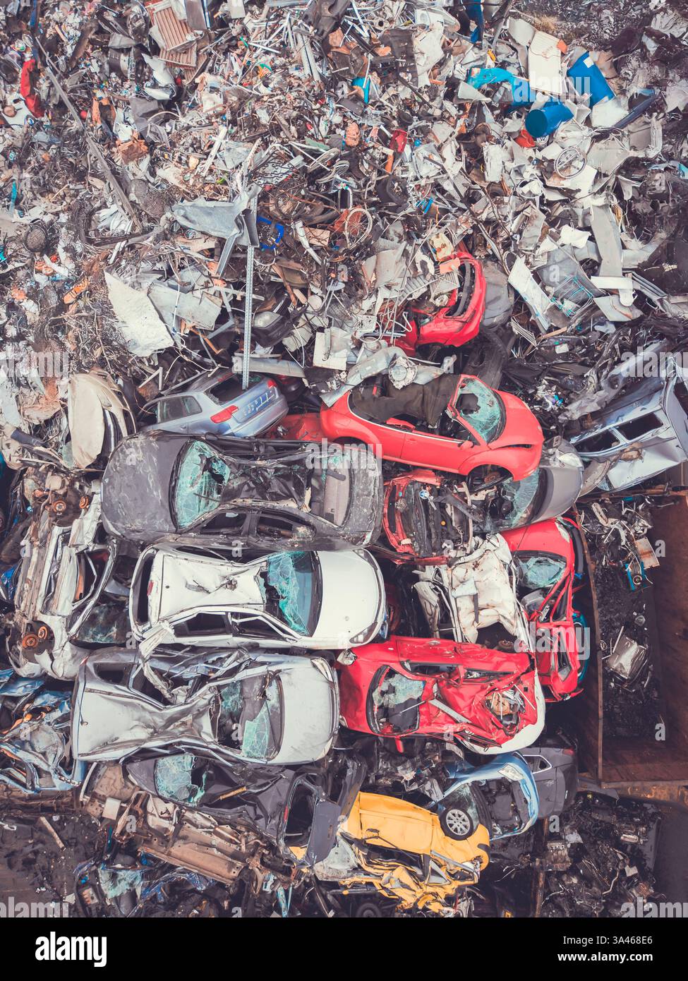 Luftaufnahme direkt über einem Stapel beschädigter Fahrzeuge und Metallschrott auf dem Hof eines Schrotthändlers zum Recycling und zur Einführung von Zöllen für Export und Import Stockfoto