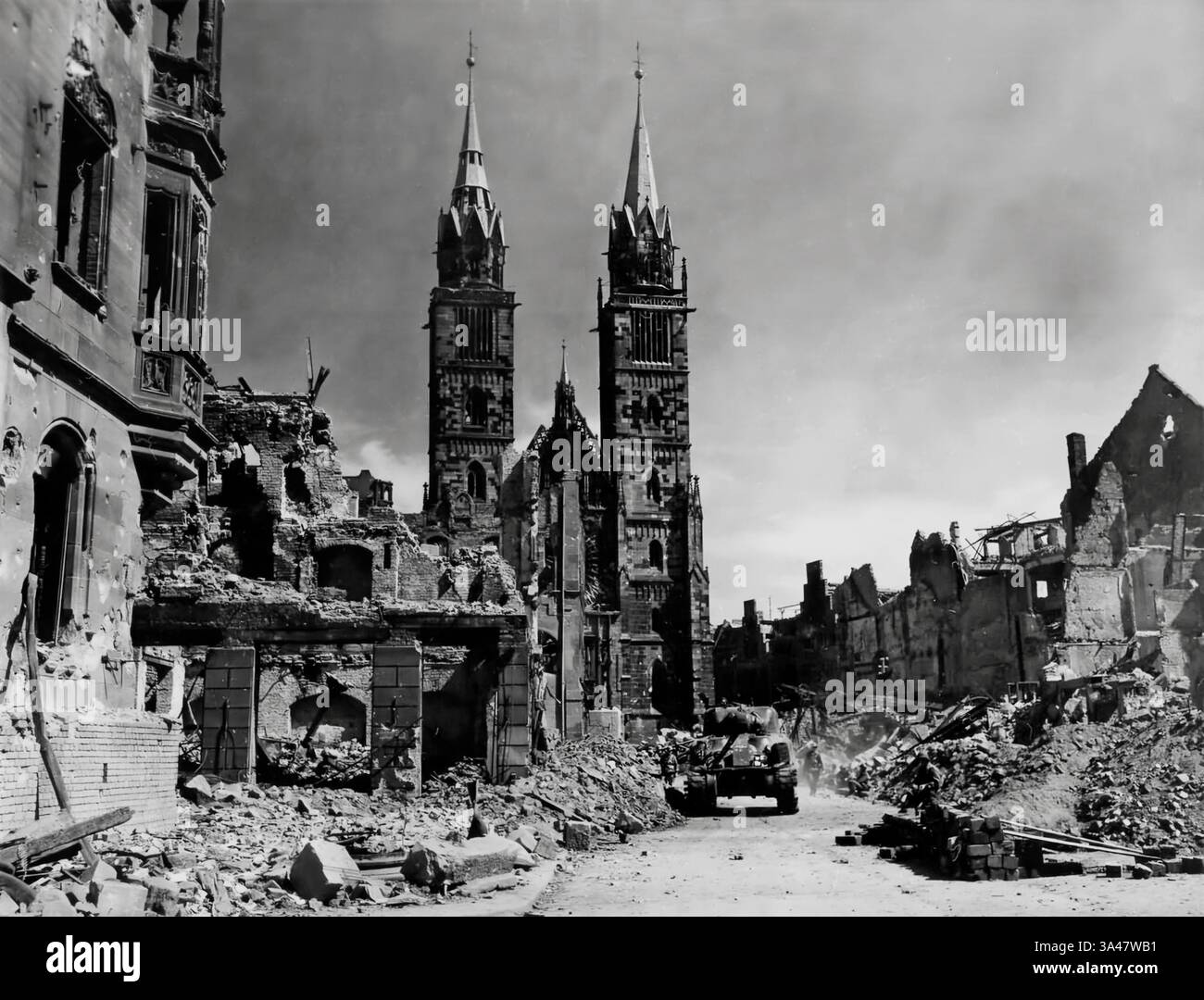 Die letzten Tage des Zweiten Weltkriegs (1945) und der 45. Infanterie-amerikanische Truppen und ein M4 Sherman-Panzer ziehen durch die Trümmer von Nürnburg in Deutschland Stockfoto