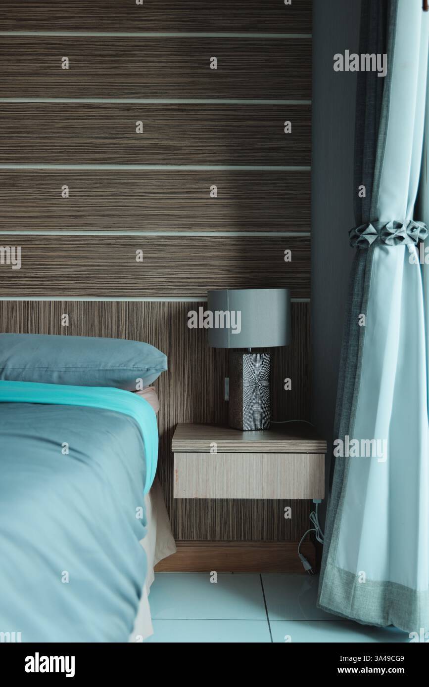 Das moderne Schlafzimmer verfügt über stilvolle Möbel, die mit wunderschönem und natürlichem Licht kombiniert werden Stockfoto