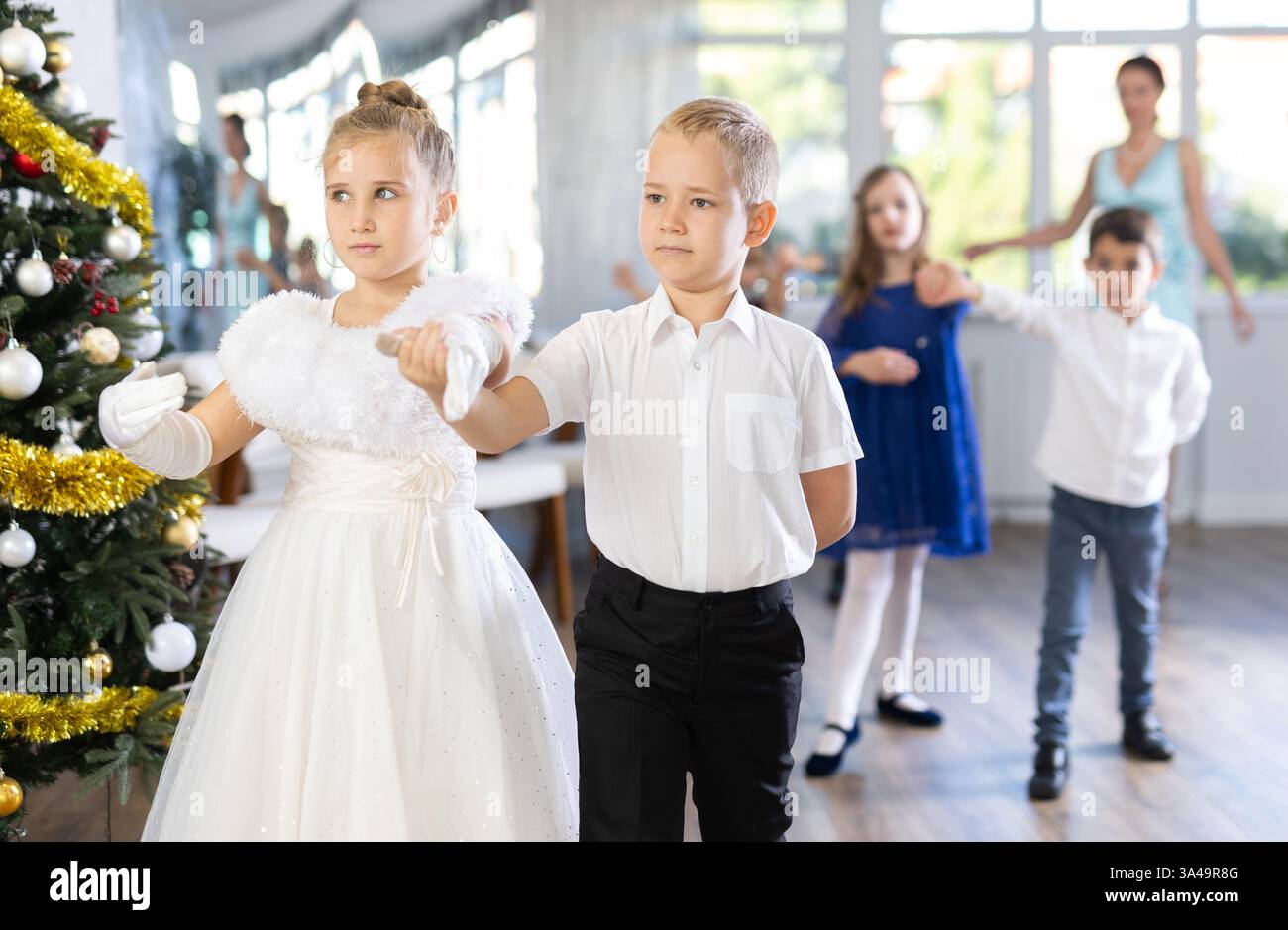 Tween Junge und Mädchen spielen Walzer während der Weihnachtsfeier in der Schule Stockfoto