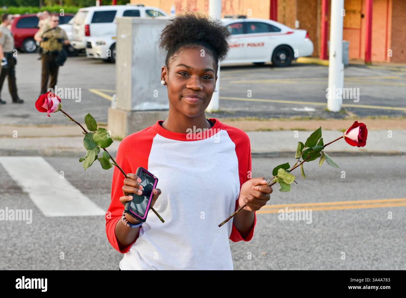 August 2014 - Ferguson, Missouri, USA S - Ein Demonstrant hält zwei Rosen in der Hoffnung auf Liebe und Frieden während des 10. Tages der Proteste auf der West Florissant Ave in Ferguson Missouri über die unbewaffnete Ermordung von Michael Brown durch einen Polizeibeamten von Ferguson (Foto: © Richard Ulreich/ZUMA Wire) Stockfoto