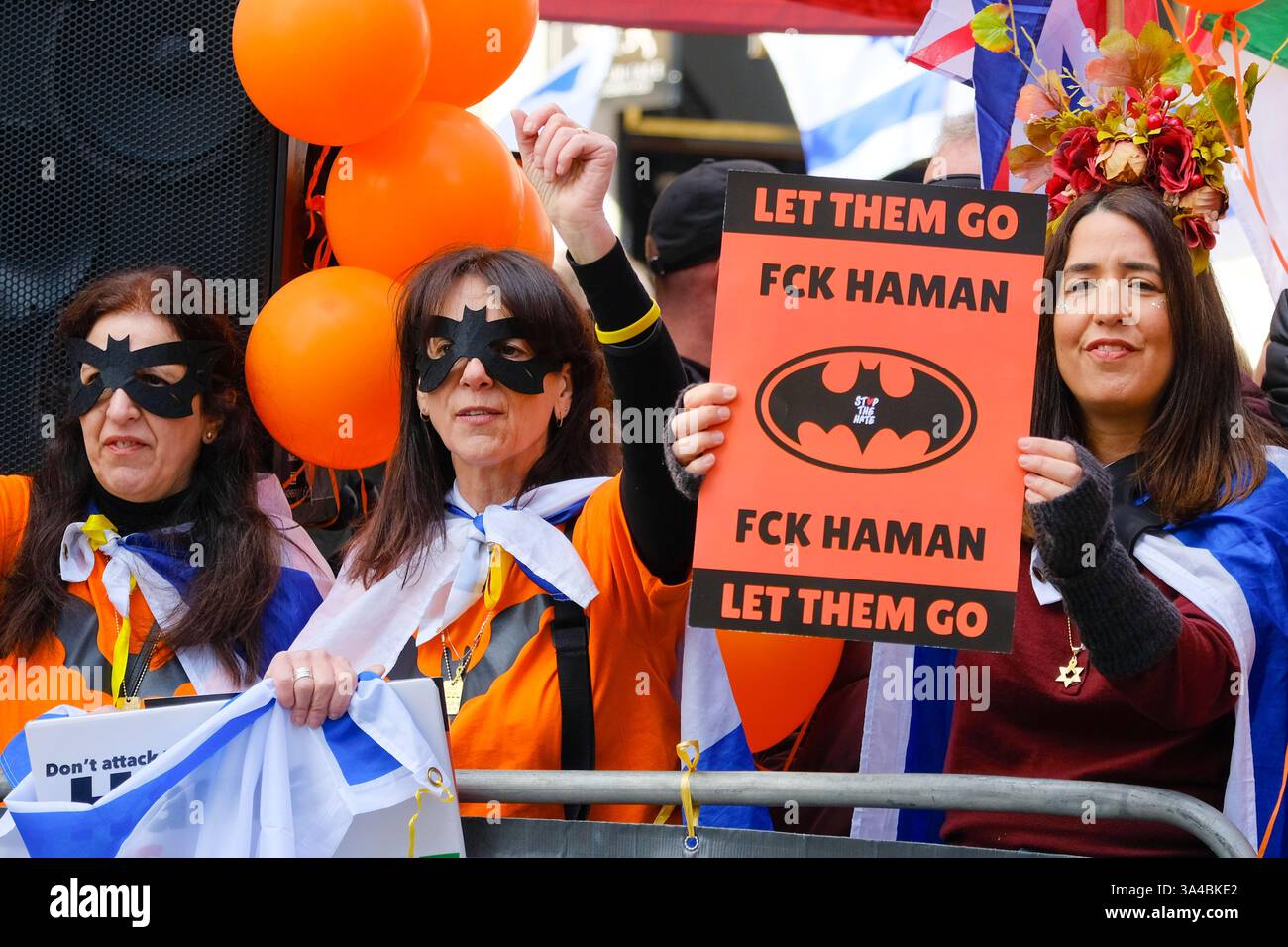 Auf dem Weg des Nationalmarsches für Palästina findet ein pro-israelischer Gegenprotest statt. Die Teilnehmer halten Schilder hoch und tragen Batman-Masken zu Ehren von Ariel Bibas während Purim. Stockfoto