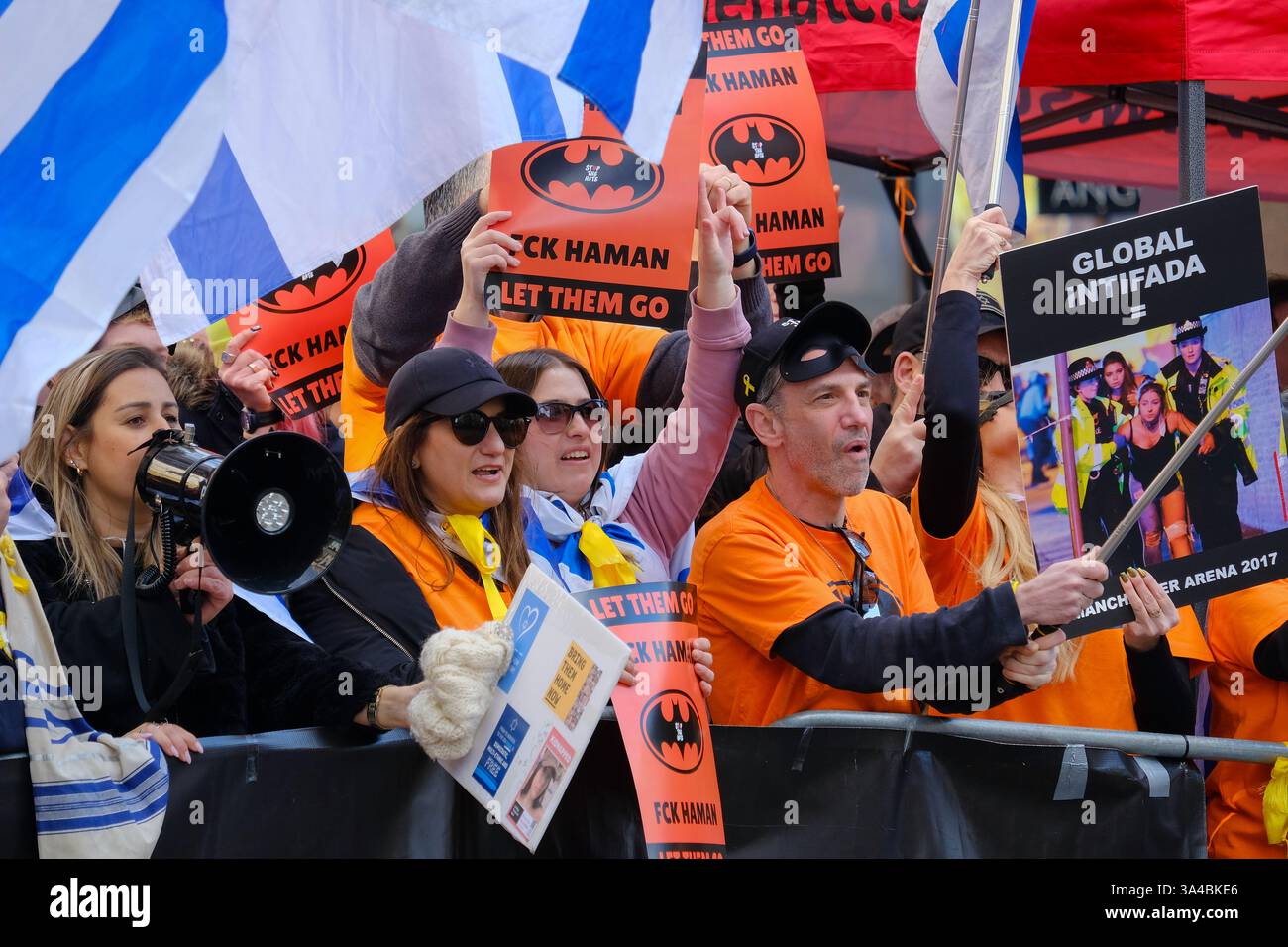Auf dem Weg des Nationalmarsches für Palästina findet ein pro-israelischer Gegenprotest statt. Die Teilnehmer halten Schilder hoch und tragen Batman-Masken zu Ehren von Ariel Bibas während Purim. Stockfoto