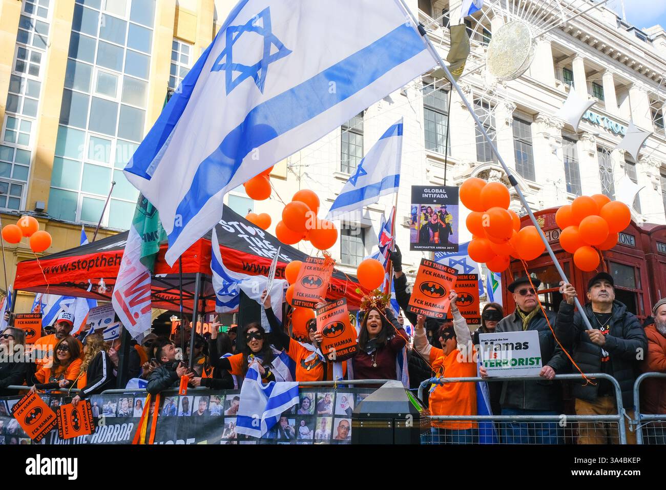 Auf dem Weg des Nationalmarsches für Palästina findet ein pro-israelischer Gegenprotest statt. Die Teilnehmer halten Schilder hoch und tragen Batman-Masken zu Ehren von Ariel Bibas während Purim. Stockfoto