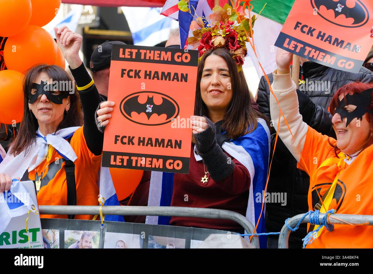 Auf dem Weg des Nationalmarsches für Palästina findet ein pro-israelischer Gegenprotest statt. Die Teilnehmer halten Schilder hoch und tragen Batman-Masken zu Ehren von Ariel Bibas während Purim. Stockfoto
