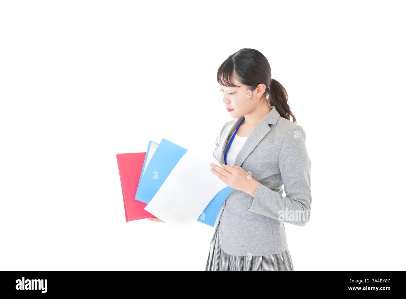 Junge Geschäftsfrau, die im Büro Papiere überprüft Stockfoto