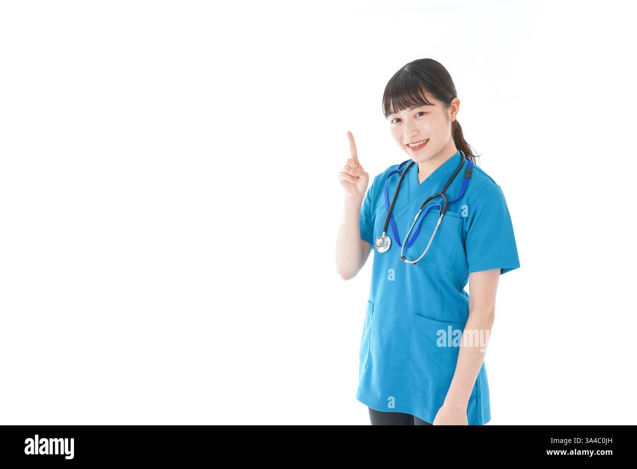 Junge Krankenschwester zeigt mit dem Finger Stockfoto