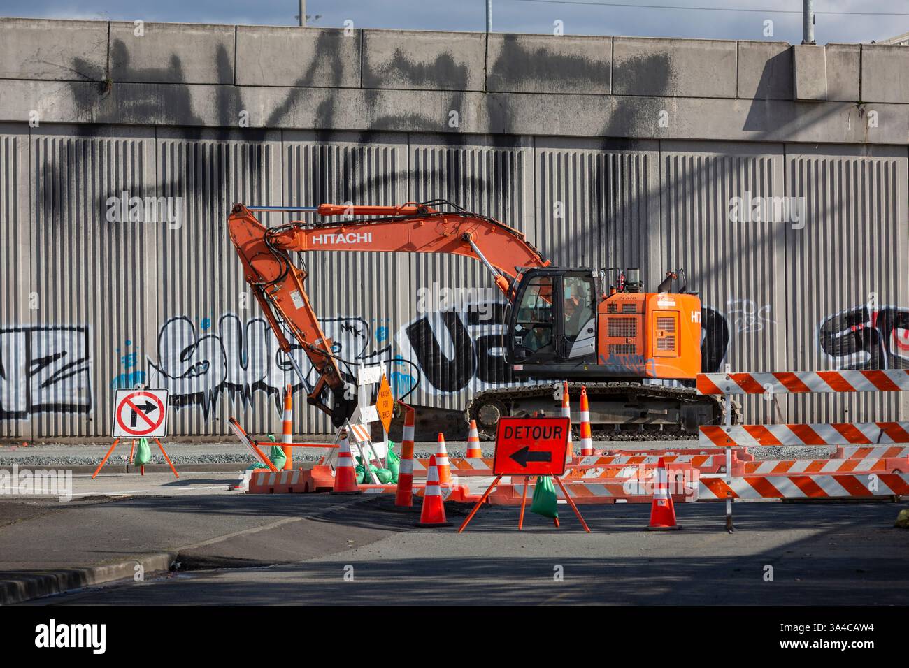 Am Sonntag, den 16. März 2025, befindet sich ein Bagger neben unzähligen Warnschildern am Alaska Way S im Stadtteil SoDo von Seattle. Die Östliche Randzone Stockfoto