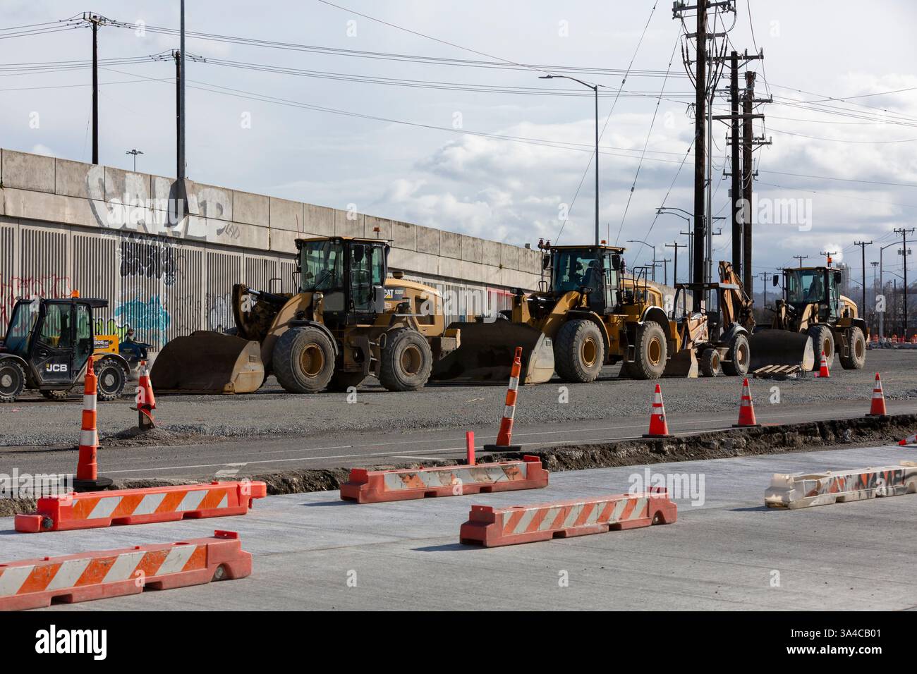 Am Sonntag, den 16. März 2025, sitzen am Alaska Way S im Stadtteil SoDo in Seattle eine Reihe von Bulldozern im Leerlauf. Der East Marginal Way Corridor Improvement P Stockfoto