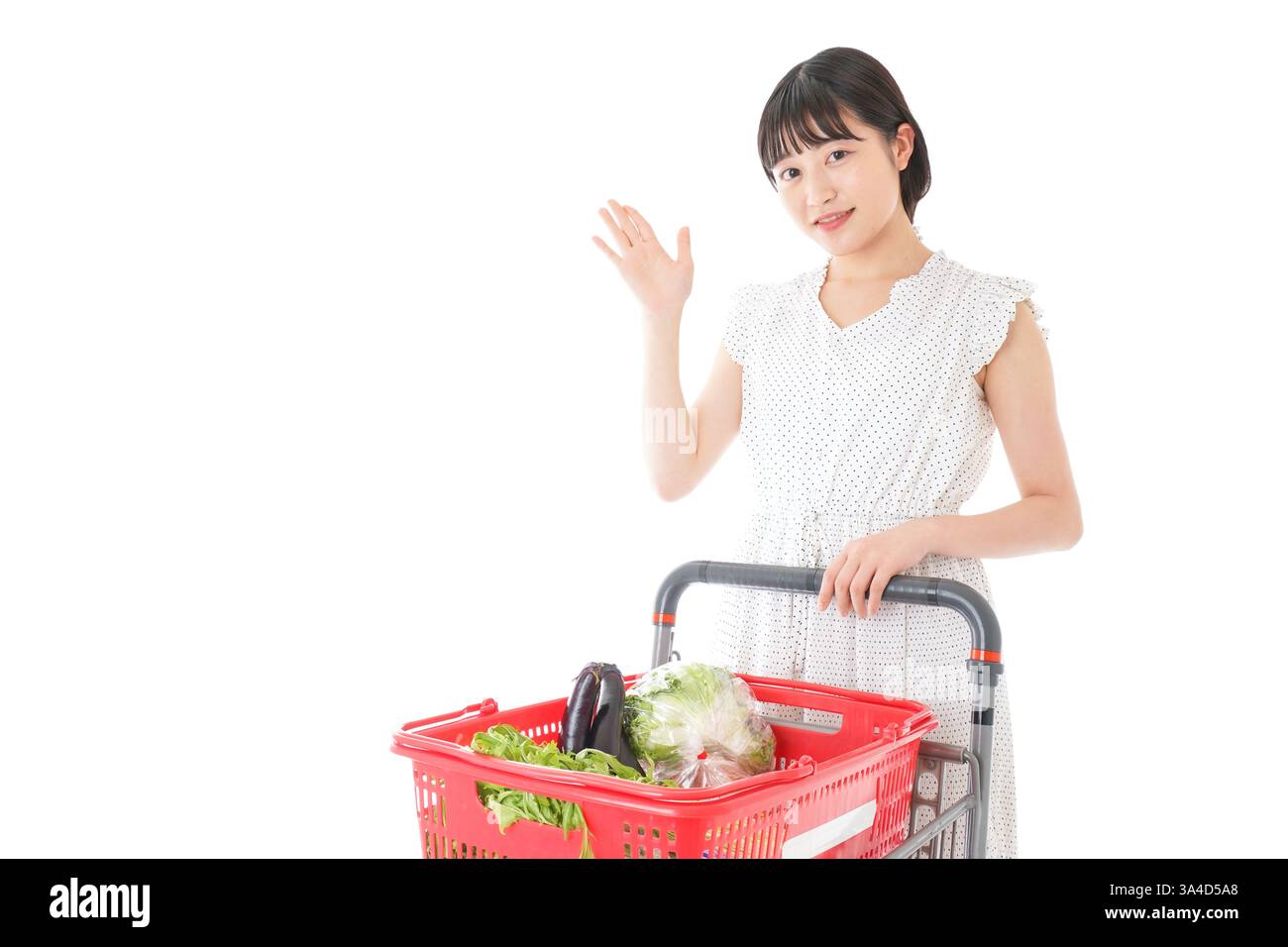 Eine junge Frau, die auf eine Verkaufsstelle in einem Supermarkt zeigt Stockfoto