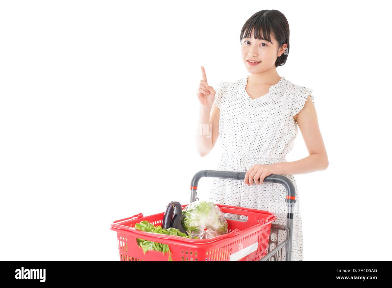 Eine junge Frau, die auf eine Verkaufsstelle in einem Supermarkt zeigt Stockfoto