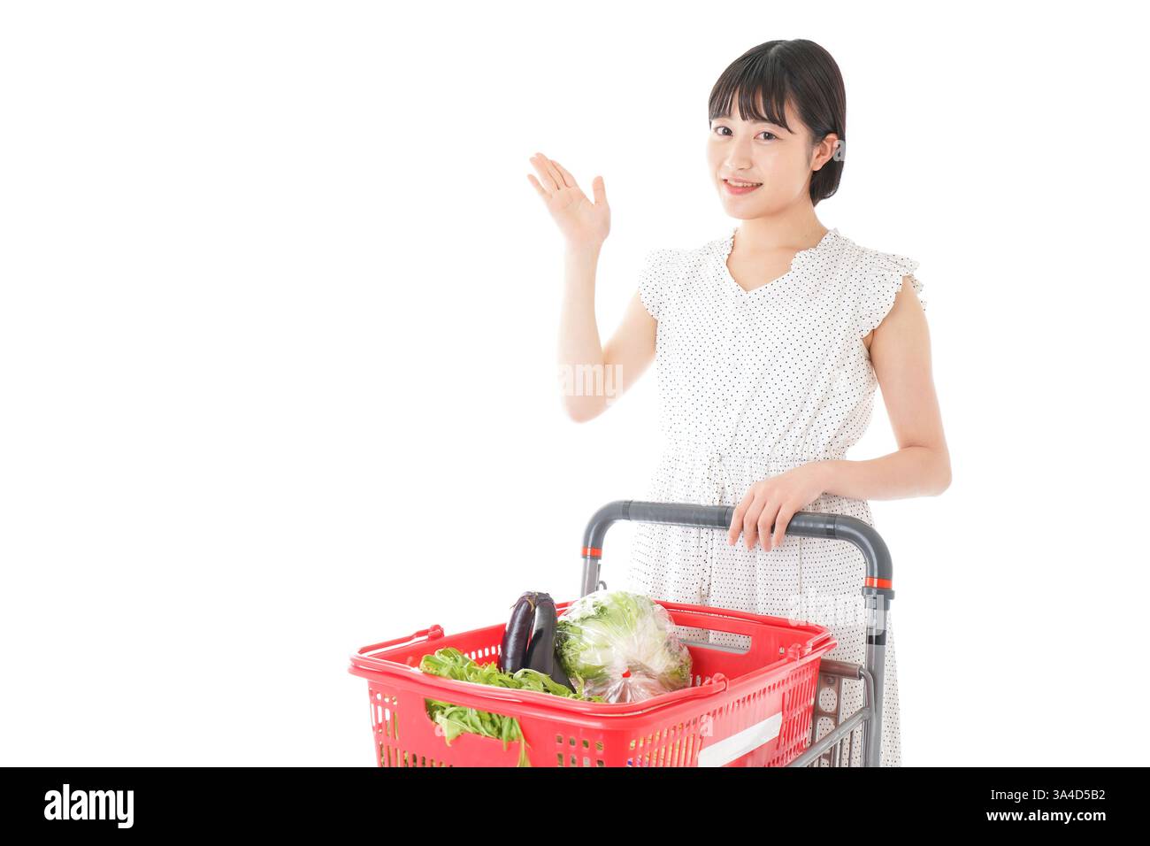 Eine junge Frau, die auf eine Verkaufsstelle in einem Supermarkt zeigt Stockfoto