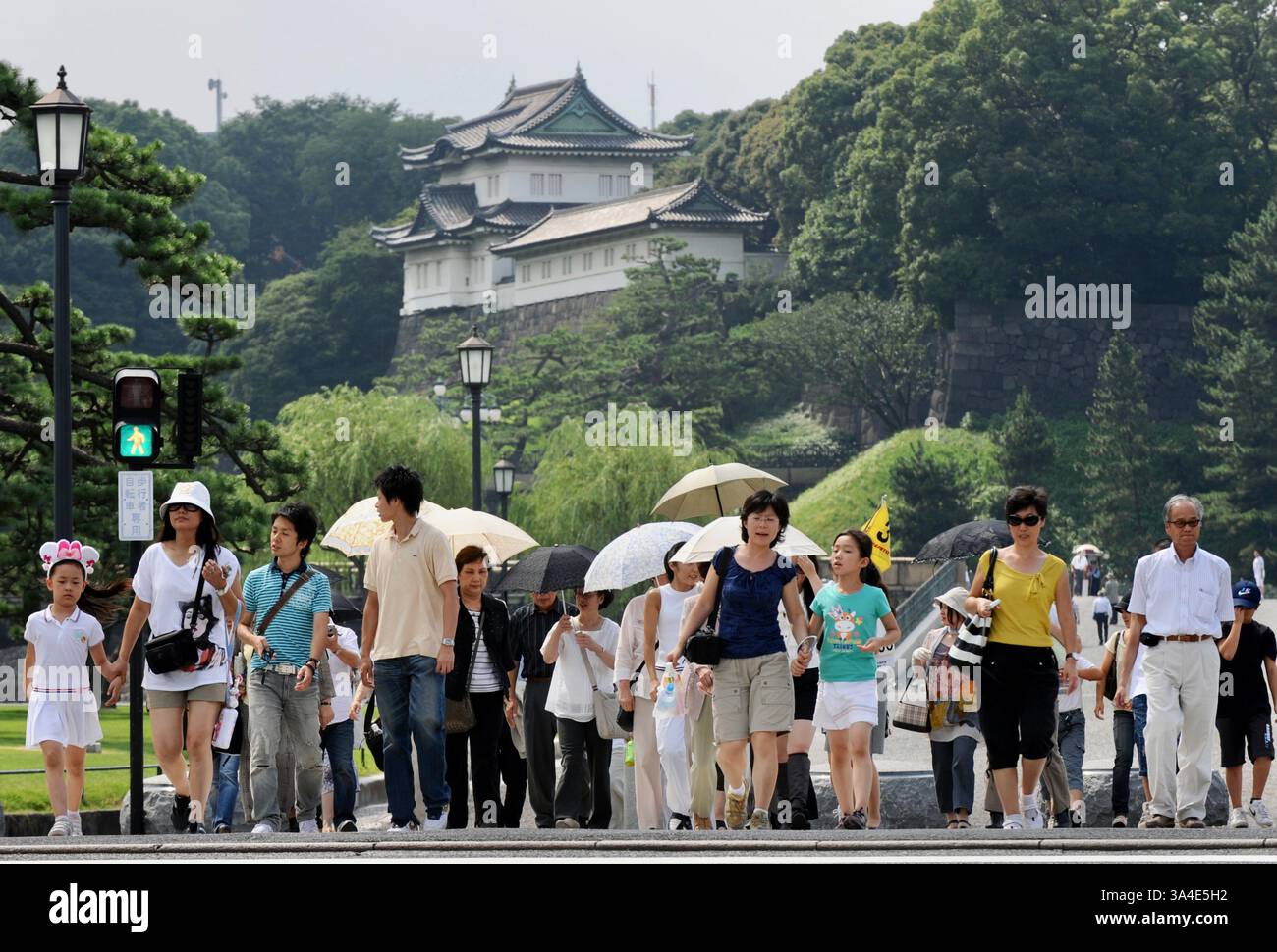 Besucher aus Übersee überqueren die Straße vor dem Kaiserpalast im Stadtteil Marunouchi in Tokio, Japan. Stockfoto