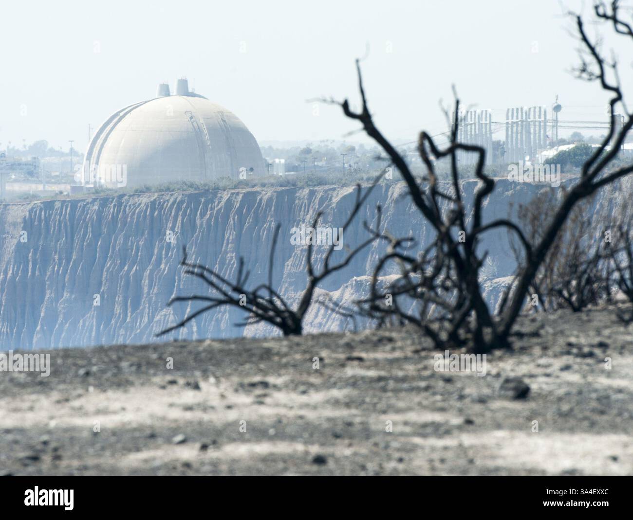 14. Mai 2014 - San Onofre, Kalifornien, USA - der Blick nach Norden aus der San Onofre State Park of SONGS Containment Dome 3 an der Spitze des Fotos mit Containment Dome 2 dahinter.  Die verkohlten Überreste von Sträuchern und Büschen, zusammen mit Asche und Schutt aus dem Pendleton West Autobahn Feuer waren noch heiß anfühlt, nach der ein Lauffeuer durch das Gebiet kommen so nah wie ein Viertel von einer Meile auf SONGS blies.  Die Fensterläden San Onofre Nuclear Generating Station hat den Prozess der Stilllegung mit einer Community Engagement-Panel bestehend aus Anwohnern sowie Bürgermeister, Stadt Counc begonnen. Stockfoto 14. Mai 2014 - San Onofre, Kalifornien, USA - der Blick nach Norden aus der San Onofre State Park of SONGS Containment Dome 3 an der Spitze des Fotos mit Containment Dome 2 dahinter.  Die verkohlten Überreste von Sträuchern und Büschen, zusammen mit Asche und Schutt aus dem Pendleton West Autobahn Feuer waren noch heiß anfühlt, nach der ein Lauffeuer durch das Gebiet kommen so nah wie ein Viertel von einer Meile auf SONGS blies.  Die Fensterläden San Onofre Nuclear Generating Station hat den Prozess der Stilllegung mit einer Community Engagement-Panel bestehend aus Anwohnern sowie Bürgermeister, Stadt Counc begonnen. Stockfoto