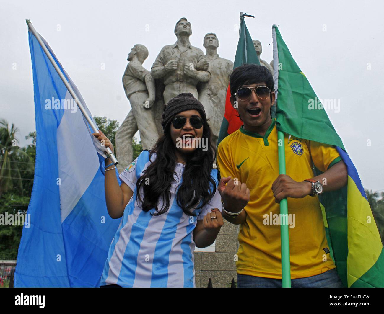10. Juni 2014 - Dhaka, Bangladesch - die Anhänger der argentinischen und brasilianischen Mannschaft trafen sich auf der Straße mit dem Trikot ihrer Lieblingsmannschaft. Die Weltmeisterschaft steht wieder auf dem Programm und bringt den überwältigenden Spielgeist und die Hitzewellen des „Fußballfiebers“ von Brasilien nach Dhaka mit sich. Die knapp zwanzig Millionen Einwohner der Hauptstadt Bangladeschs feiern mit großem Interesse die Weltmeisterschaft. Zahlreiche Flaggen der teilnehmenden Nationen winken auf den Straßen und auf den Dächern der Häuser, Geschäfte und sogar Büros. Die erscheinenden Mannschaftstrikots und andere Produkte im Zusammenhang mit der Weltmeisterschaft werden gerade dabei sein Stockfoto