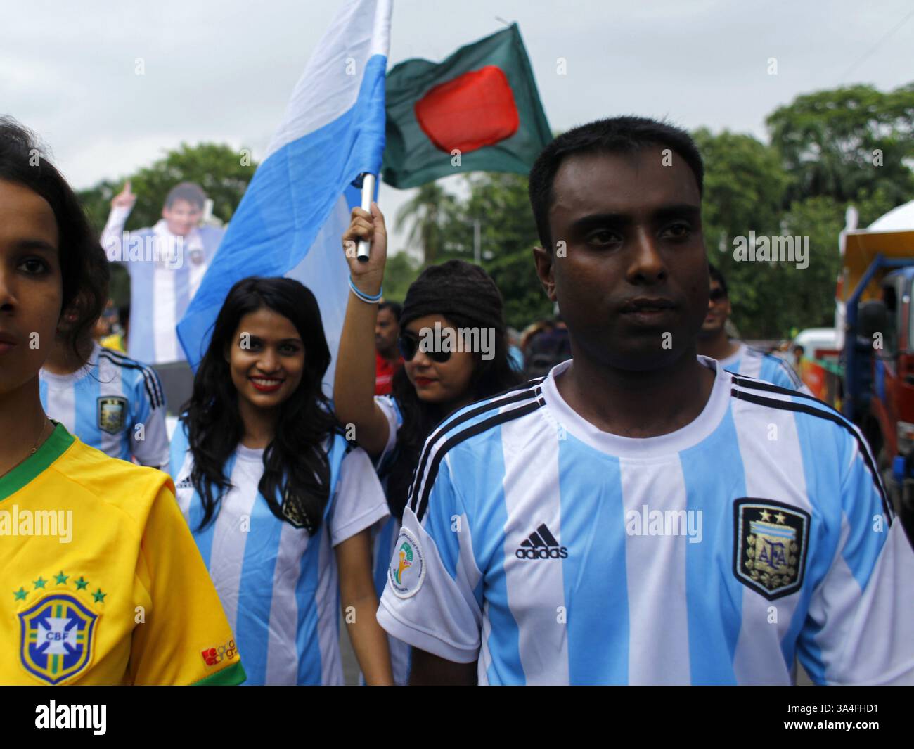 10. Juni 2014 - Dhaka, Bangladesch - die Anhänger der argentinischen und brasilianischen Mannschaft trafen sich auf der Straße mit dem Trikot ihrer Lieblingsmannschaft. Die Weltmeisterschaft steht wieder auf dem Programm und bringt den überwältigenden Spielgeist und die Hitzewellen des „Fußballfiebers“ von Brasilien nach Dhaka mit sich. Die knapp zwanzig Millionen Einwohner der Hauptstadt Bangladeschs feiern mit großem Interesse die Weltmeisterschaft. Zahlreiche Flaggen der teilnehmenden Nationen winken auf den Straßen und auf den Dächern der Häuser, Geschäfte und sogar Büros. Die erscheinenden Mannschaftstrikots und andere Produkte im Zusammenhang mit der Weltmeisterschaft werden gerade dabei sein Stockfoto