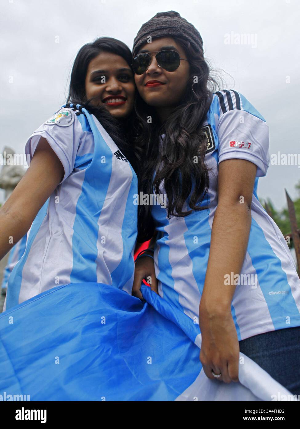 10. Juni 2014 - Dhaka, Bangladesch - Anhänger des argentinischen Fußballteams trafen sich auf der Straße mit dem Trikot ihrer Lieblingsmannschaft. Die Weltmeisterschaft steht wieder vor uns und bringt ihren überwältigenden Spielgeist und Hitzewellen des „Fußballfiebers“ auf dem ganzen Weg von Brasilien nach Dhaka mit sich. Die knapp zwanzig Millionen Einwohner der Hauptstadt Bangladeschs feiern mit großem Interesse die Weltmeisterschaft. Zahlreiche Flaggen der teilnehmenden Nationen winken auf den Straßen und auf den Dächern der Häuser, Geschäfte und sogar Büros. Die Trikots und andere Produkte im Zusammenhang mit der Weltmeisterschaft werden derzeit angeboten Stockfoto